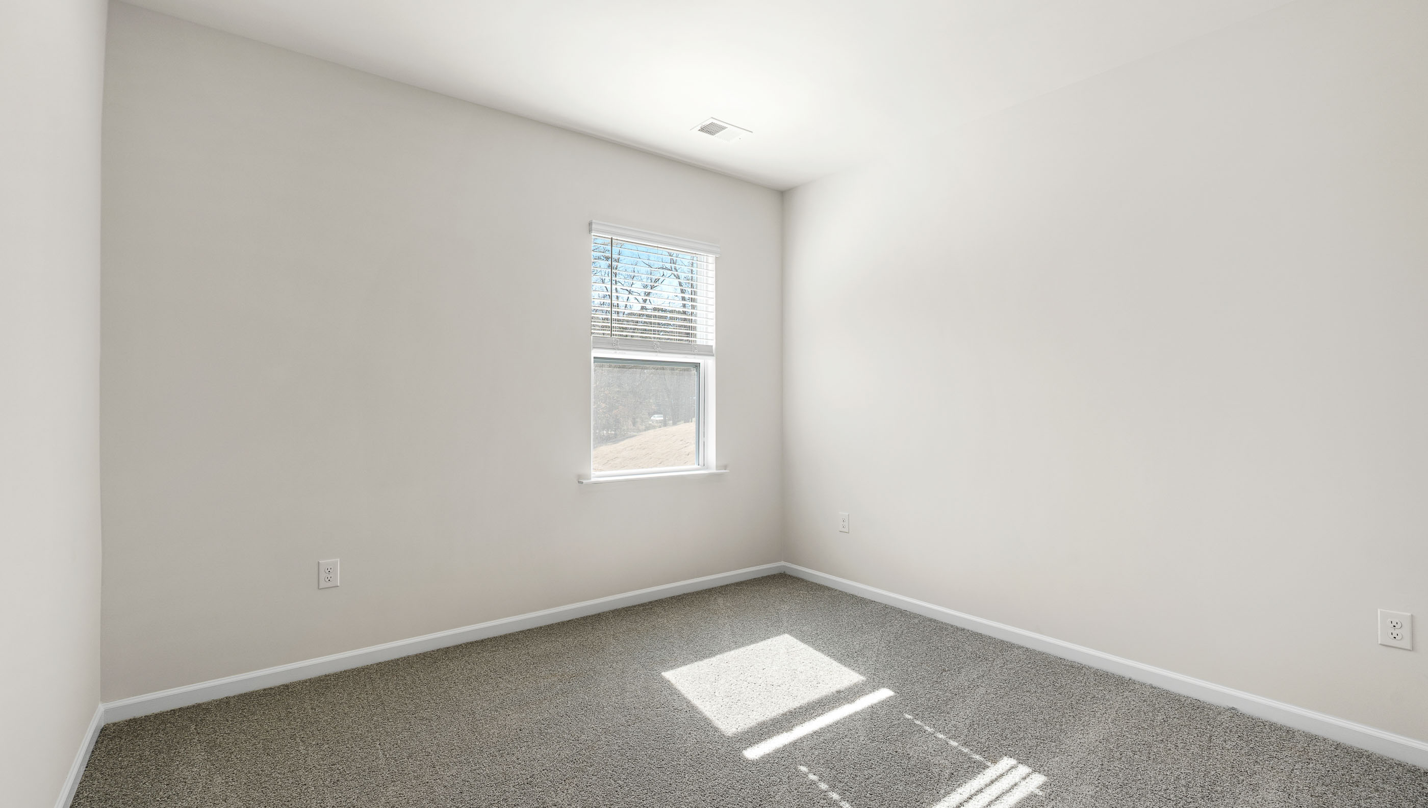 Bedroom with carpet and window.