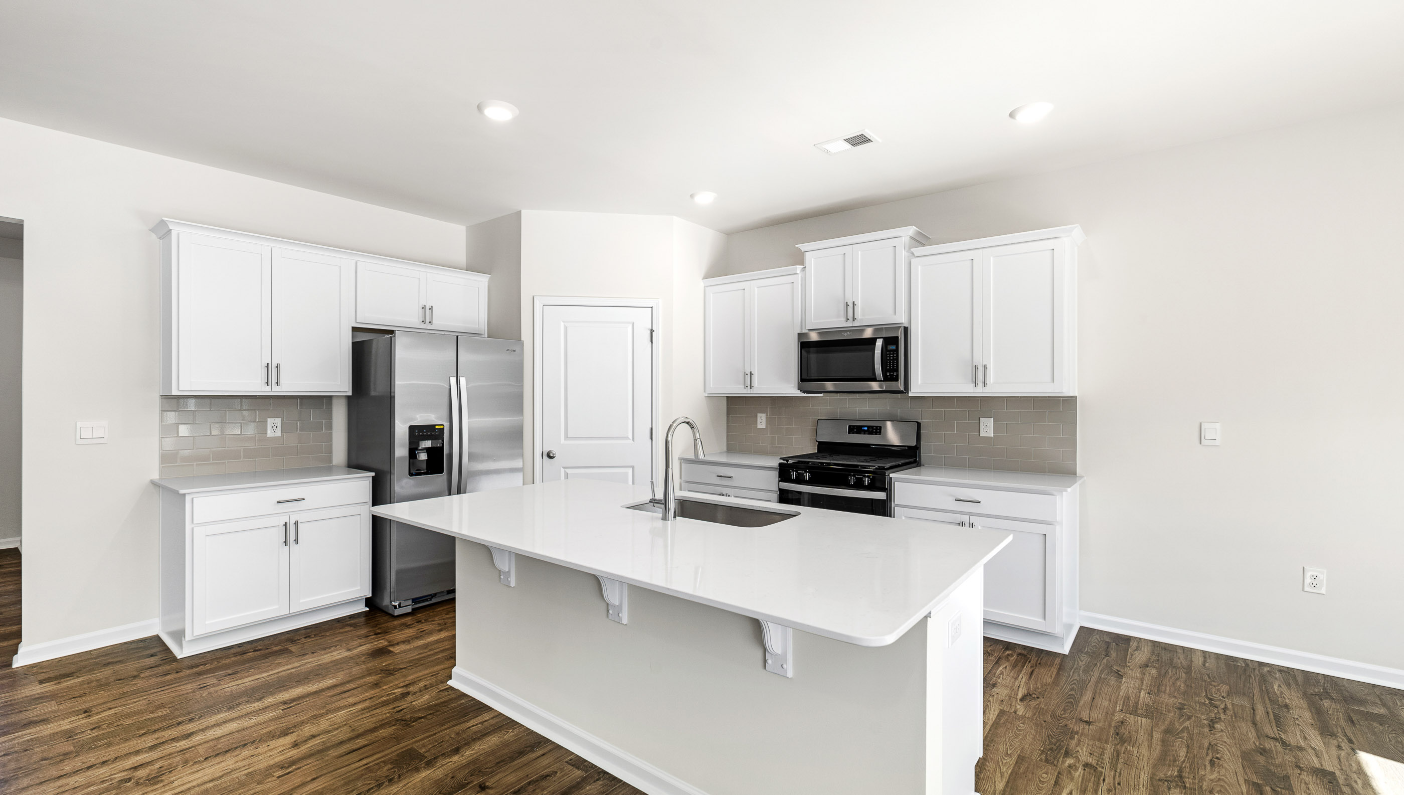 Kitchen with island and stainless steel appliances.