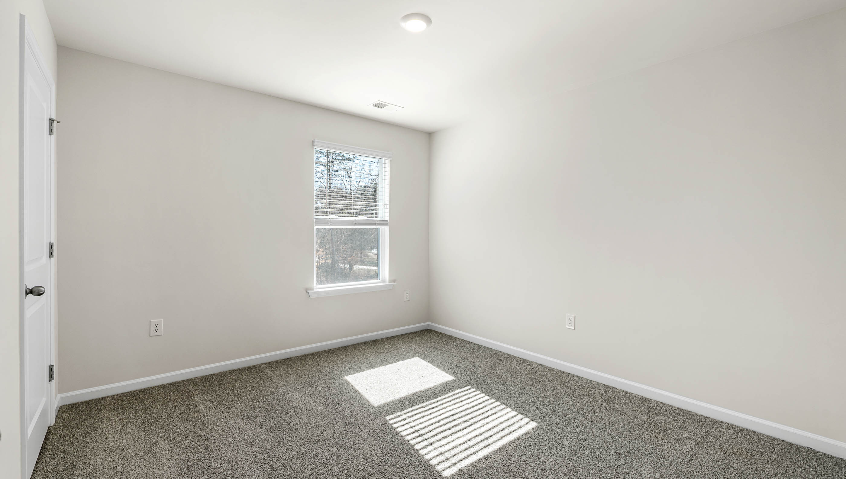 Bedroom with carpet and window.a