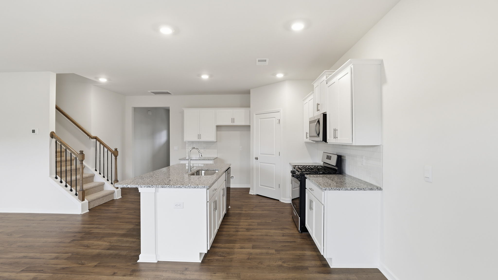 Kitchen and island with quartz countertops.