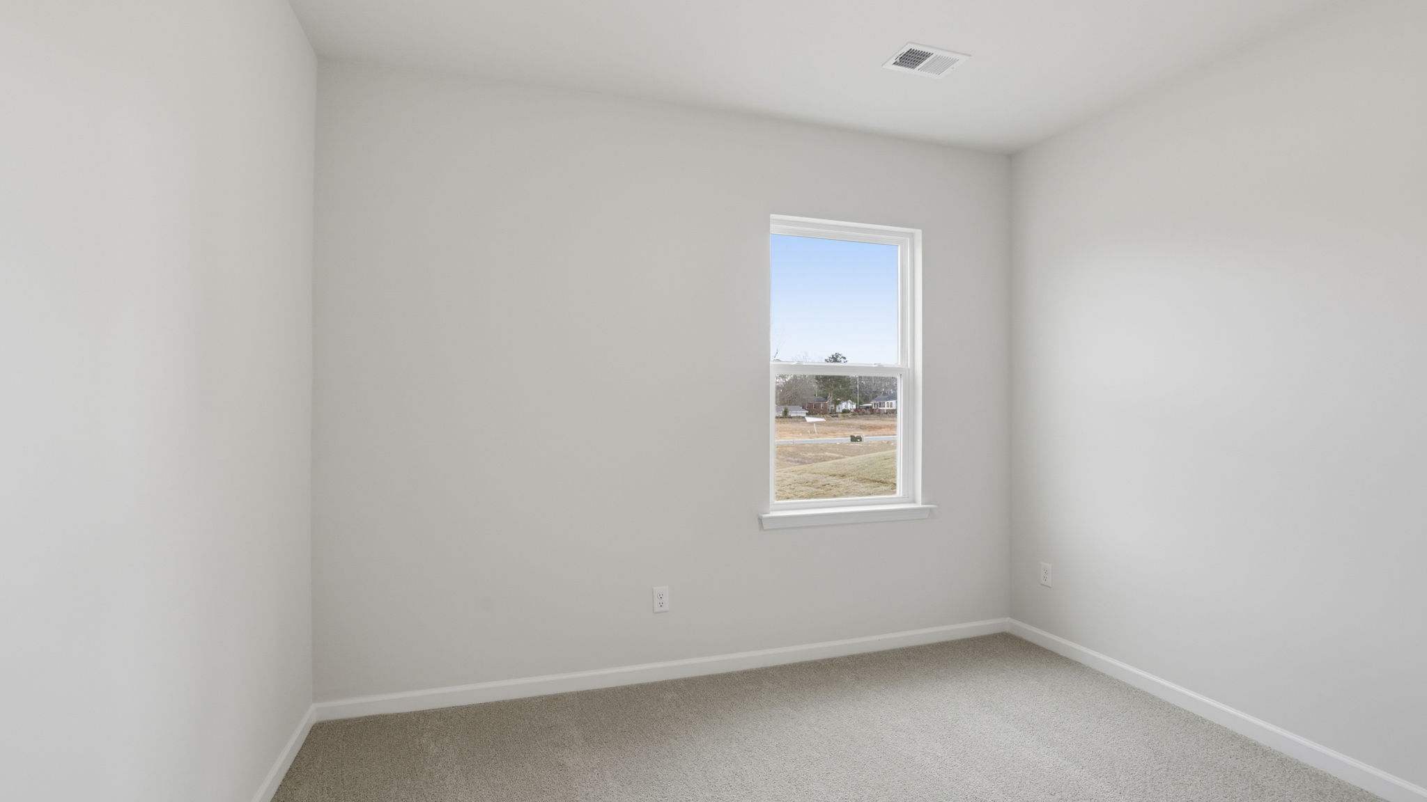 Bedroom with window and carpet on the main level.