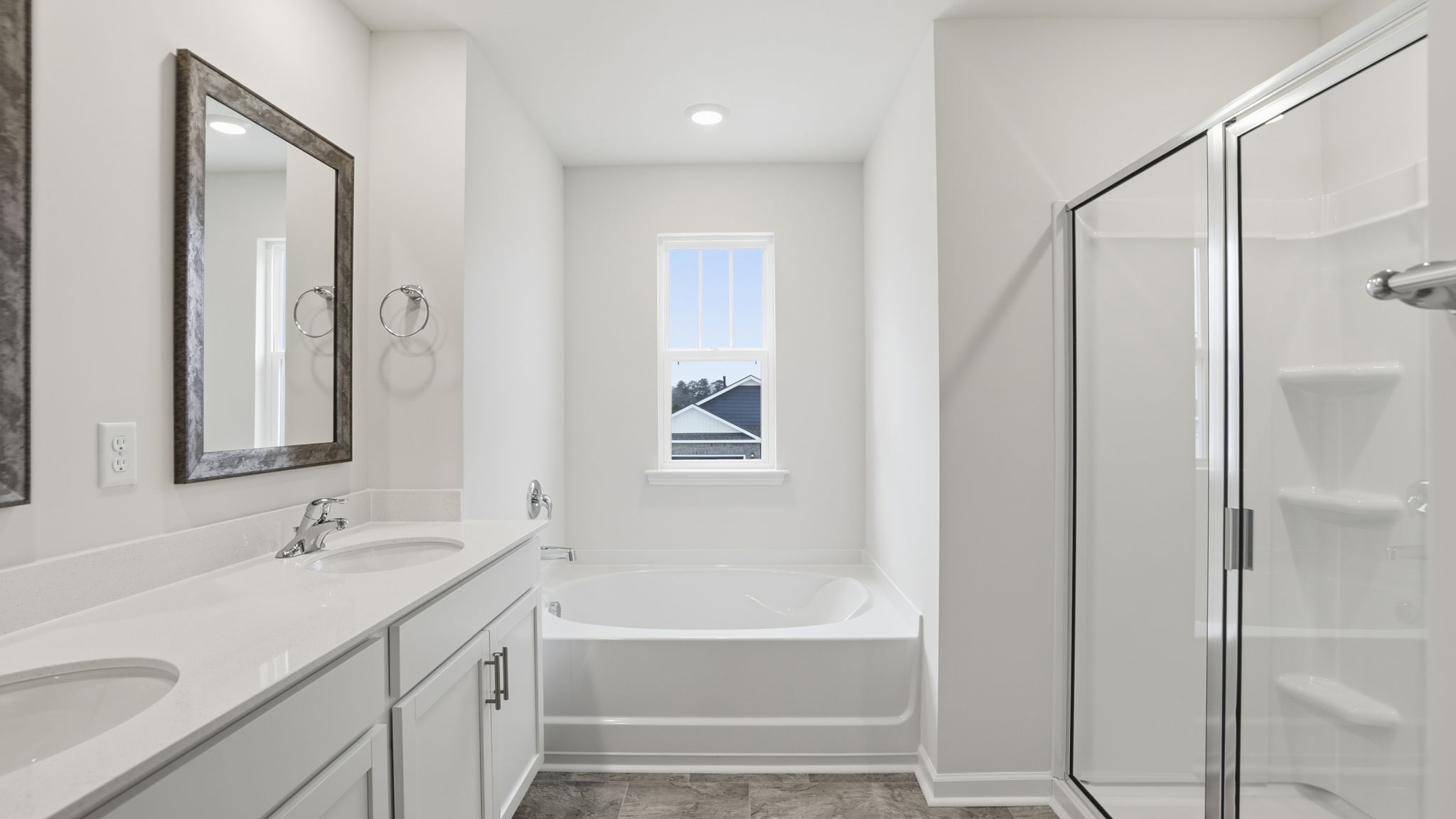 Primary bathroom with dual sink vanity and mirrors.
