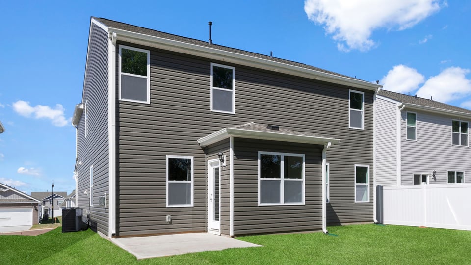 back exterior of home with large backyard.