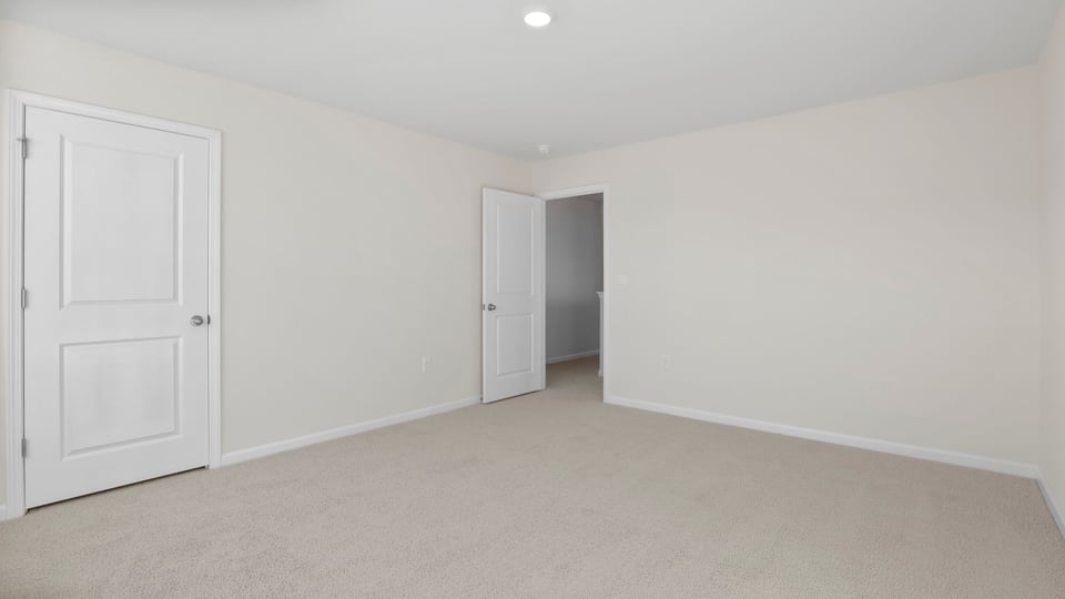Bedroom with large window and carpet.