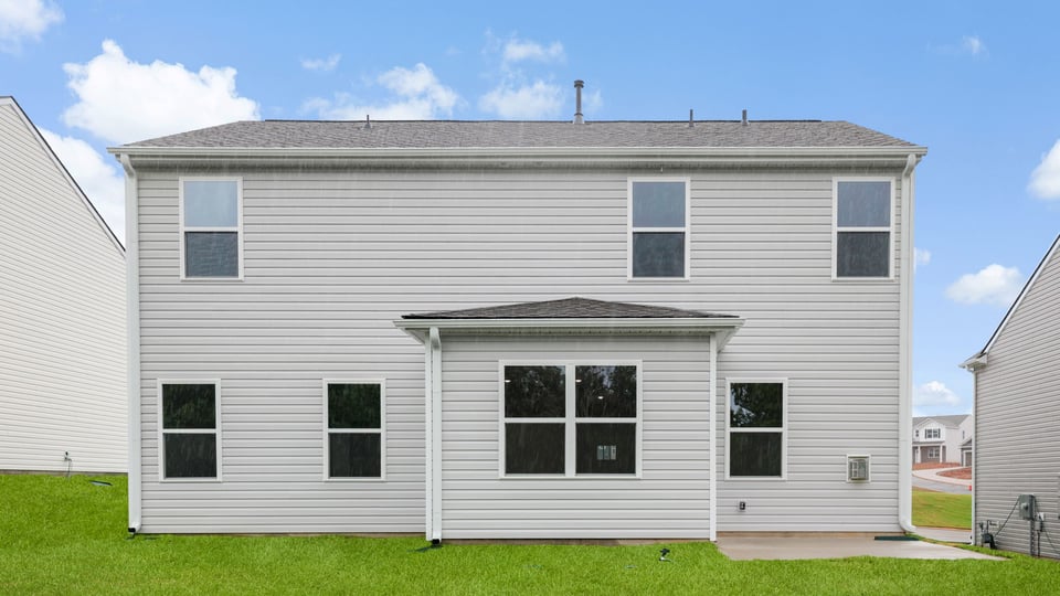 Back exterior of home with large backyard.