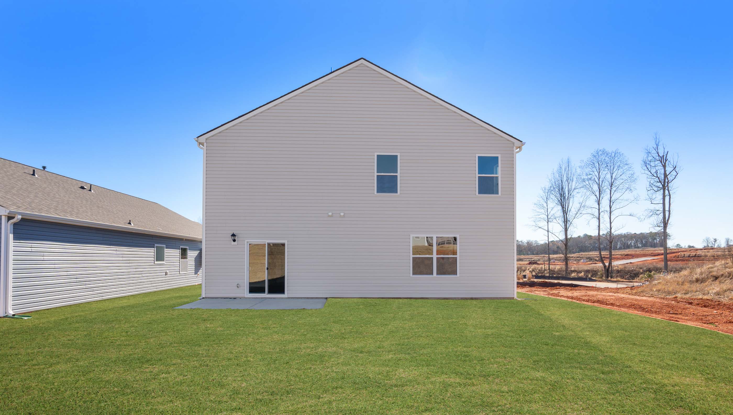 Back exterior of home with large backyard.