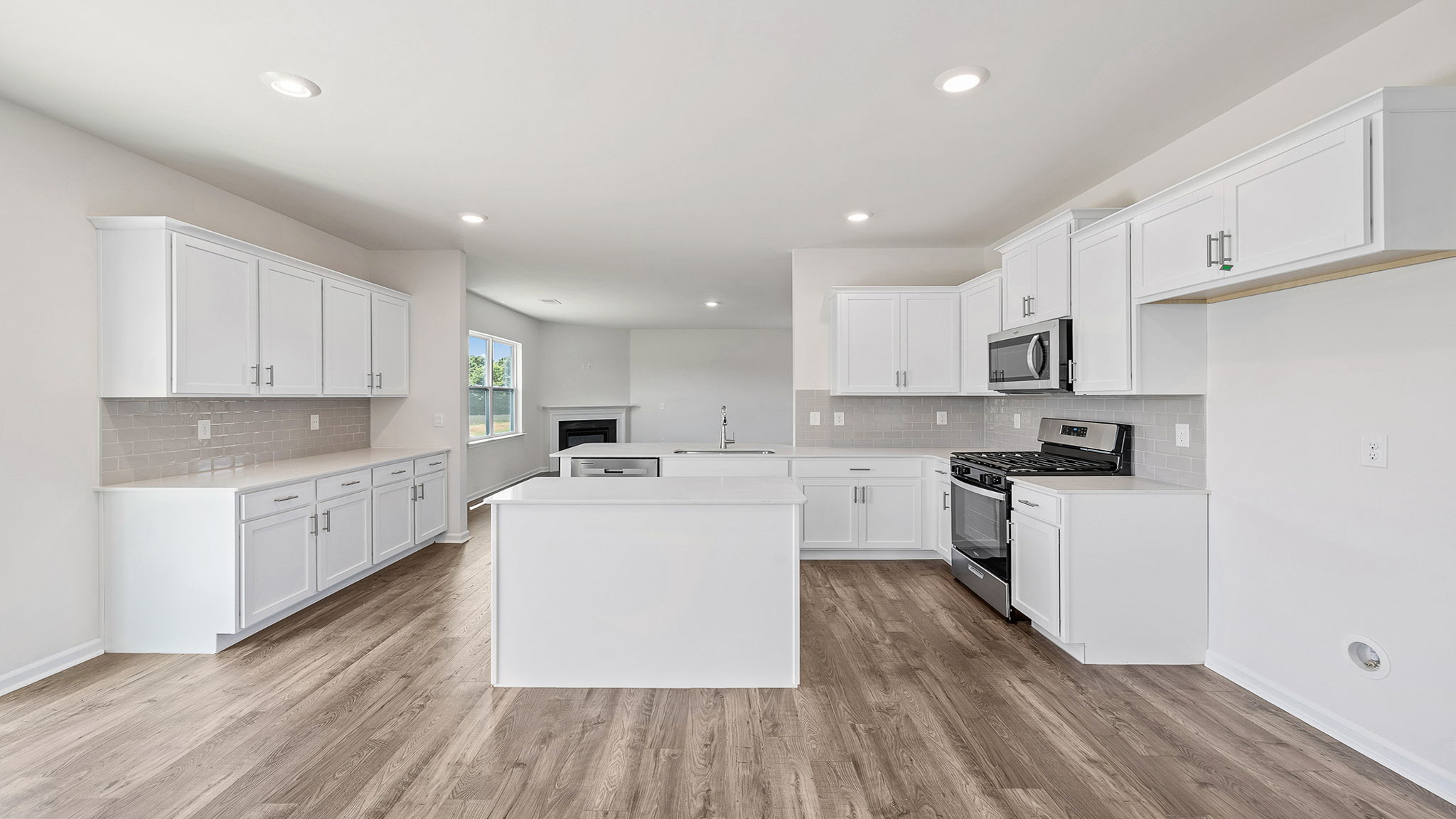 Kitchen and island with stainless steel appliances.