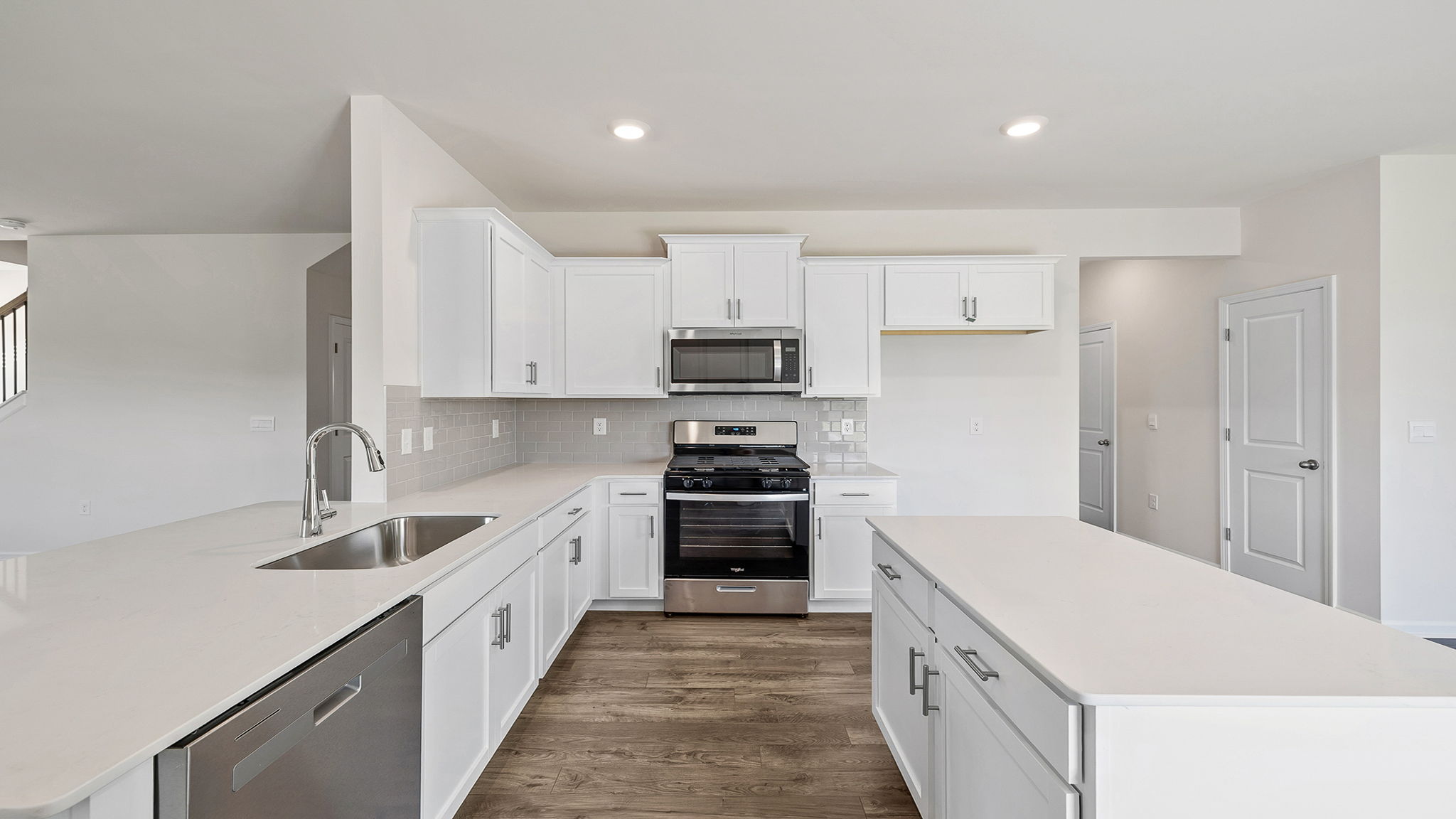 Kitchen and island with stainless steel appliances.