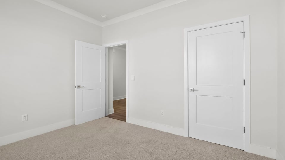 Bedroom with carpet and windows.