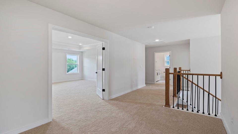 Stairs with carpet and hallway to bedrooms.