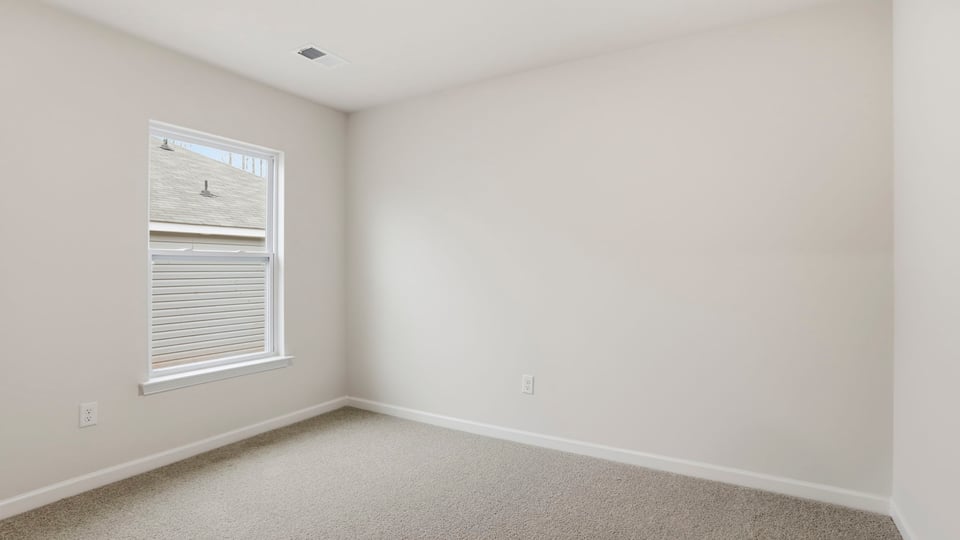 Bedroom with window and carpet.