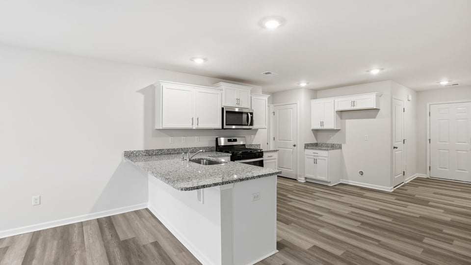 View of kitchen and view of hallway toward the entry.