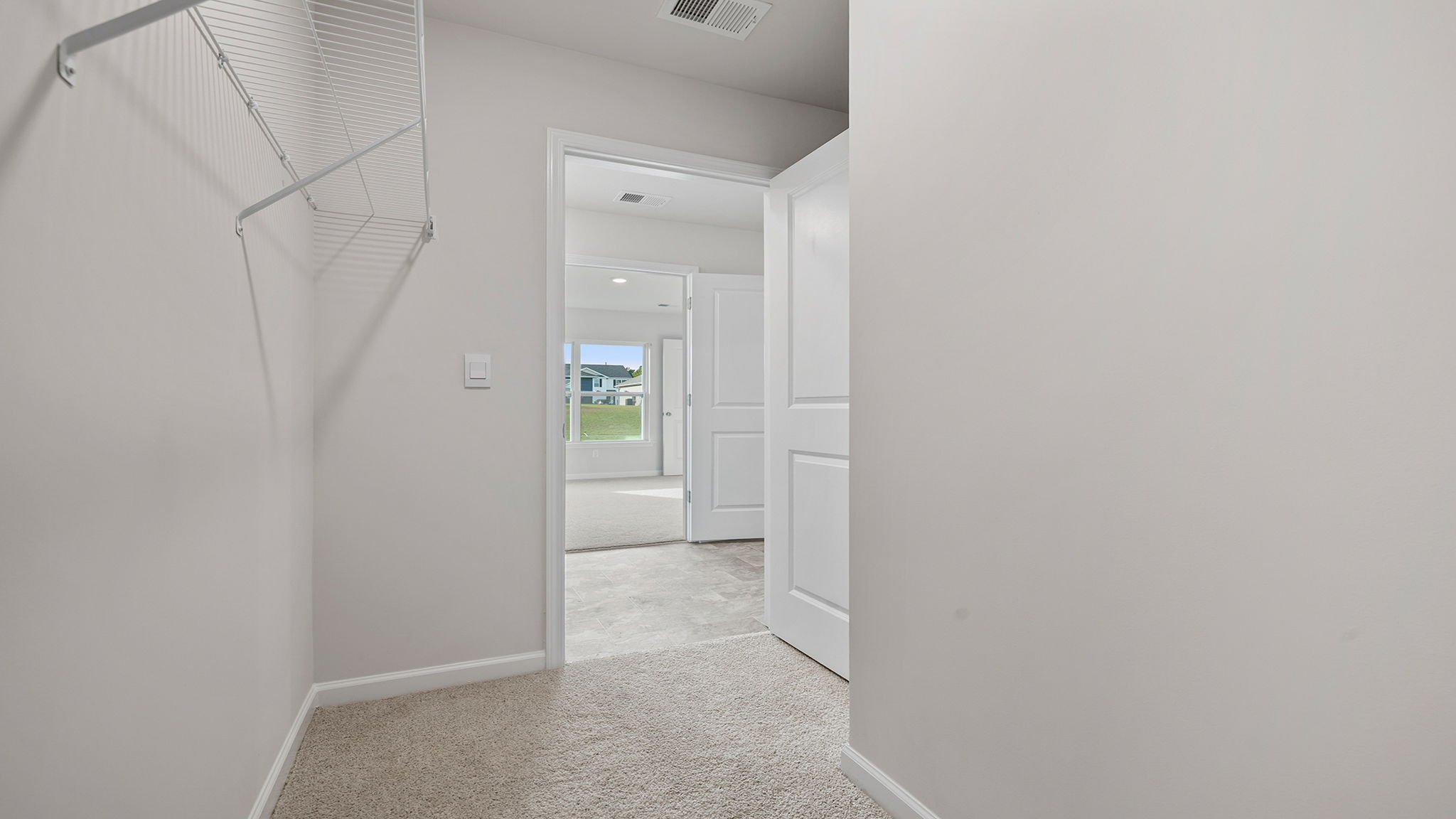 Primary closet with carpet.