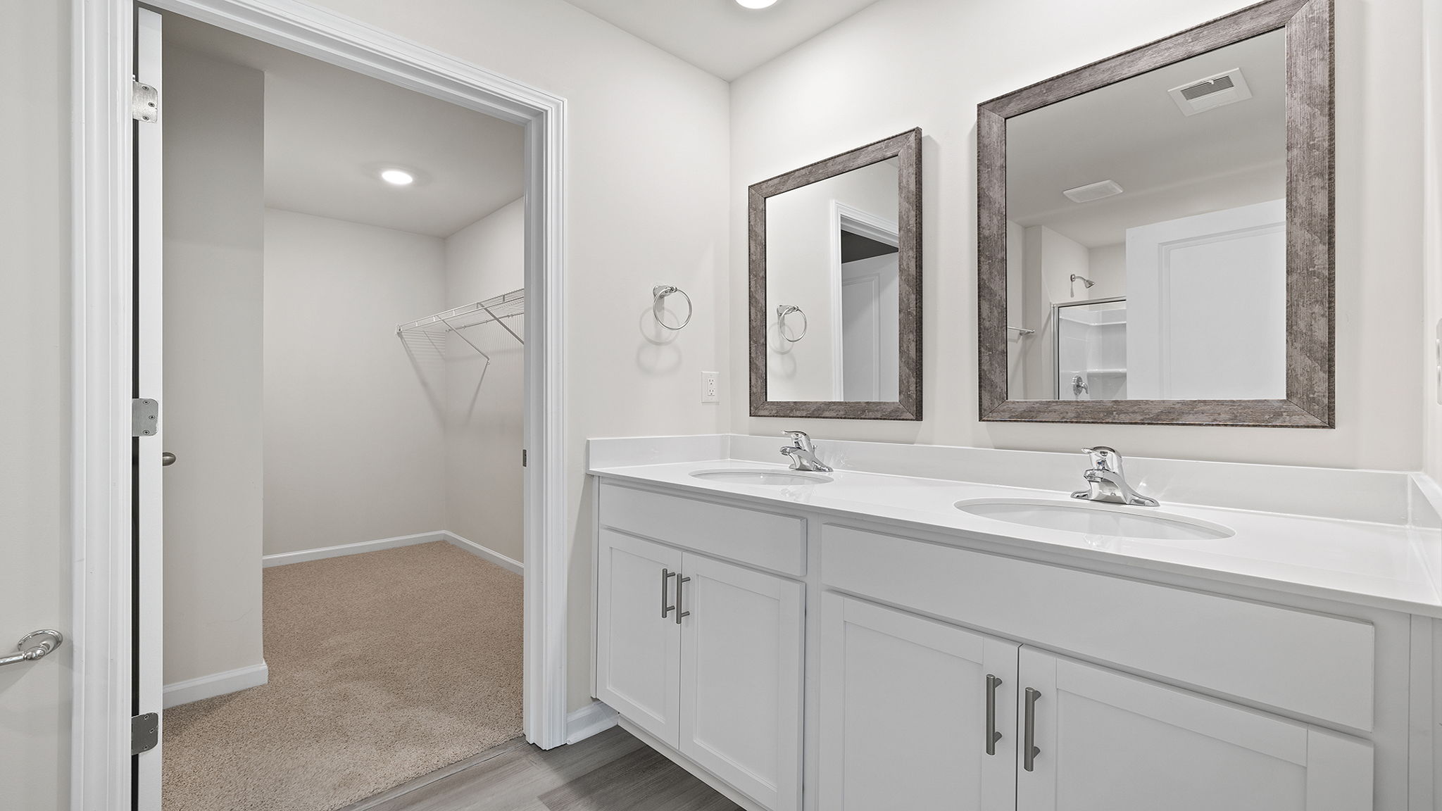 Primary bathroom with dual sink vanity and mirrors.