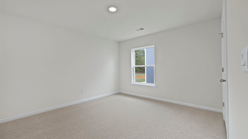 Front bedroom with window and carpet.