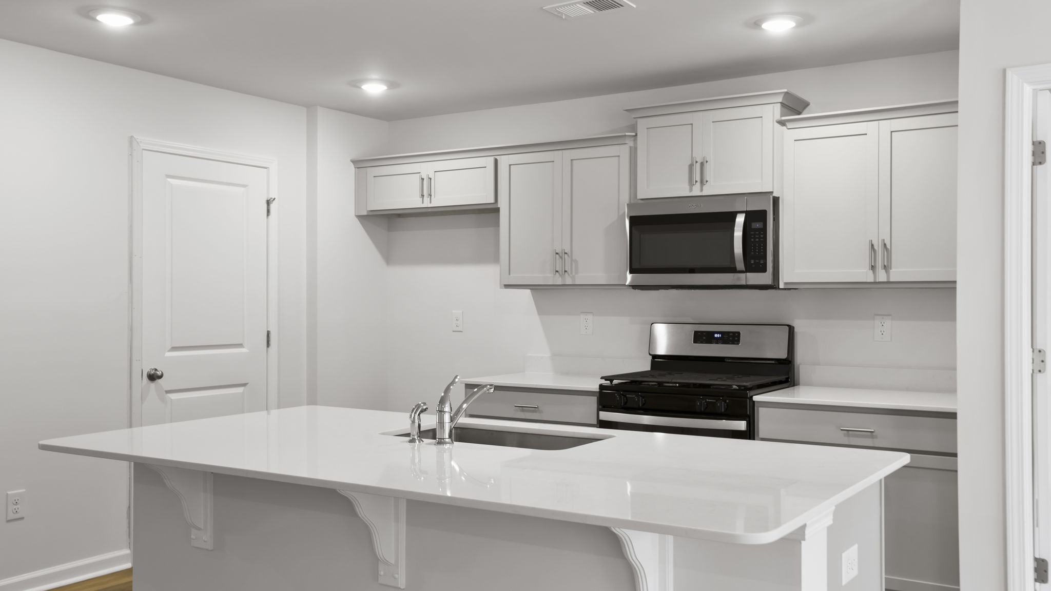 Island and kitchen have quartz countertops.