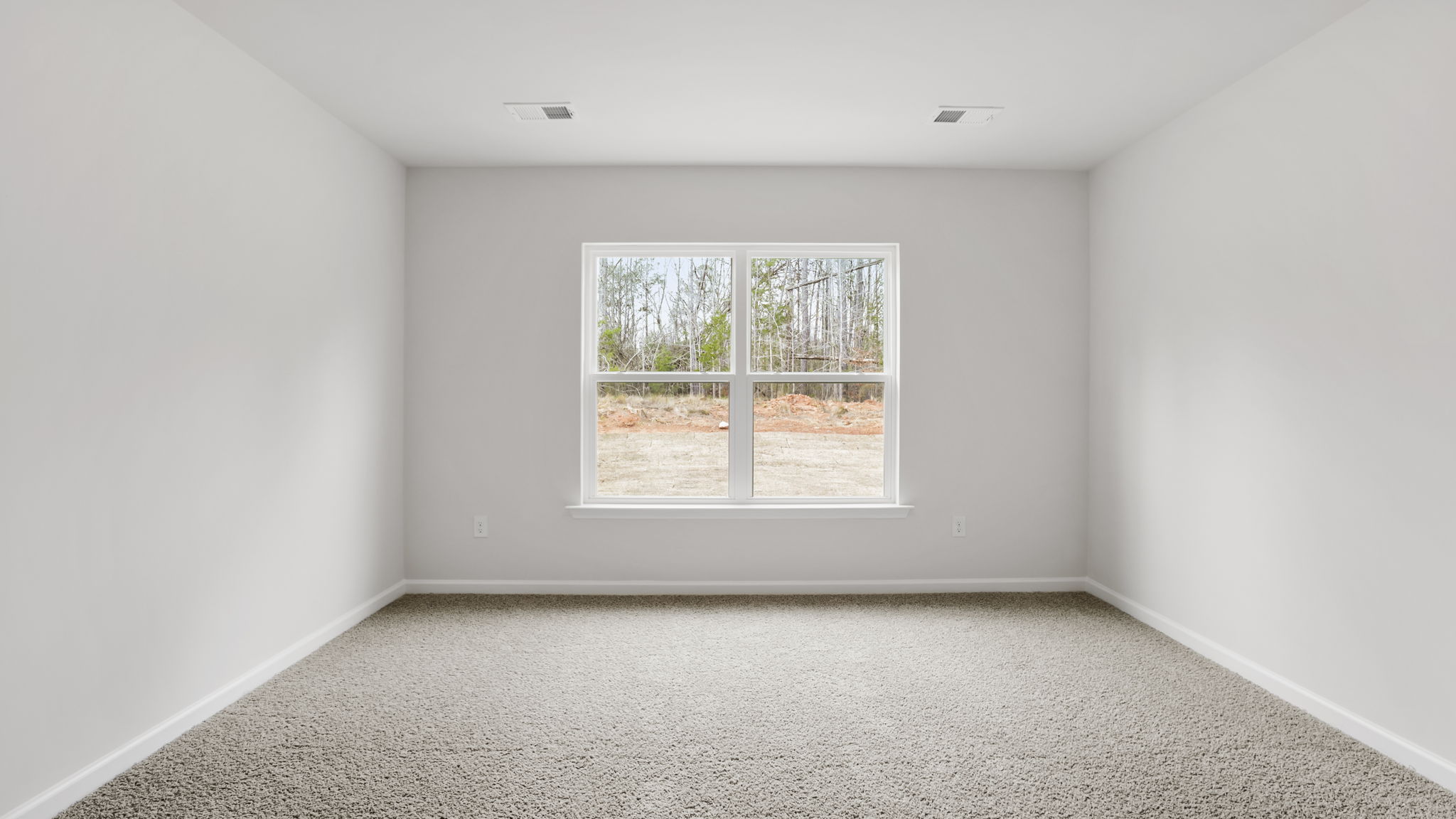 Primary bedroom with carpet and window.