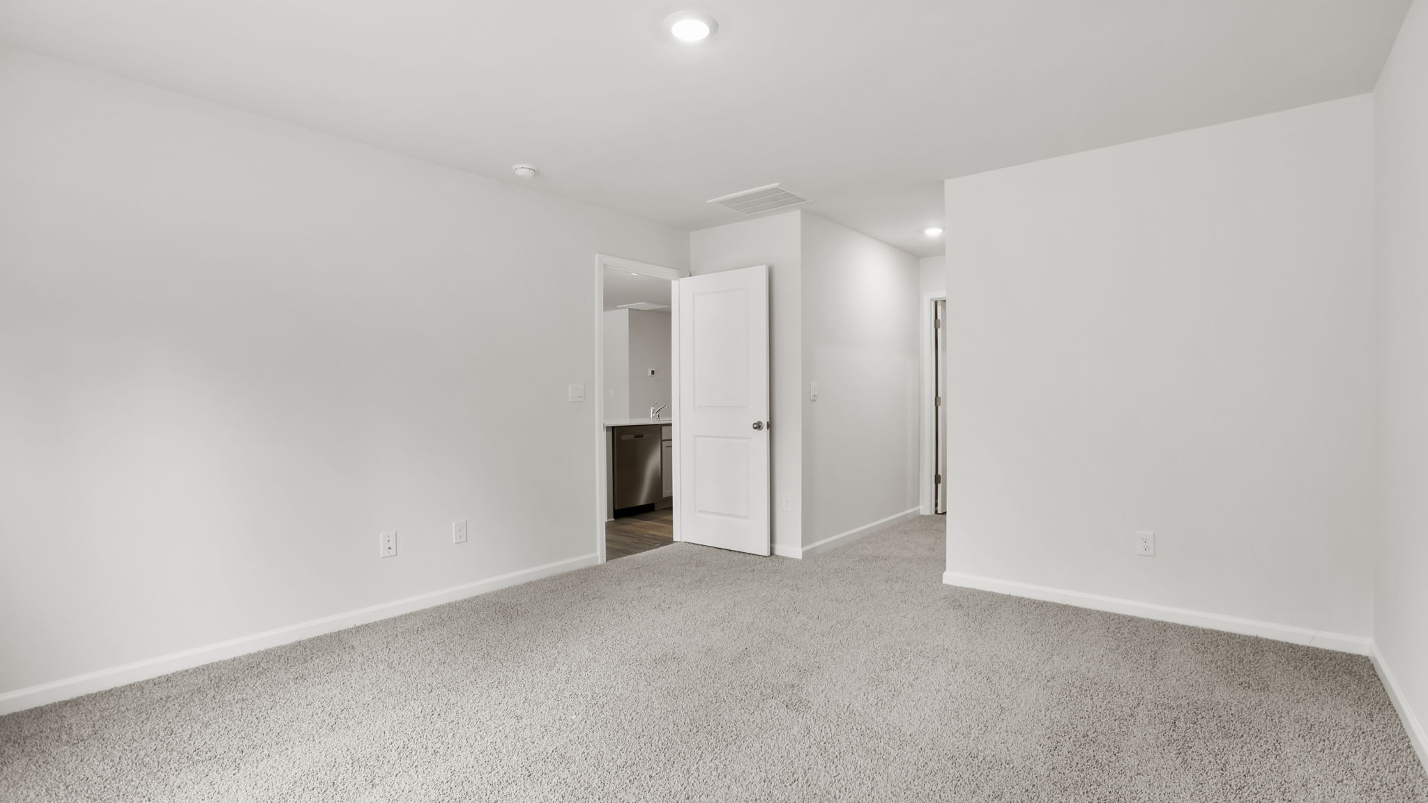 Primary bedroom with carpet and window.