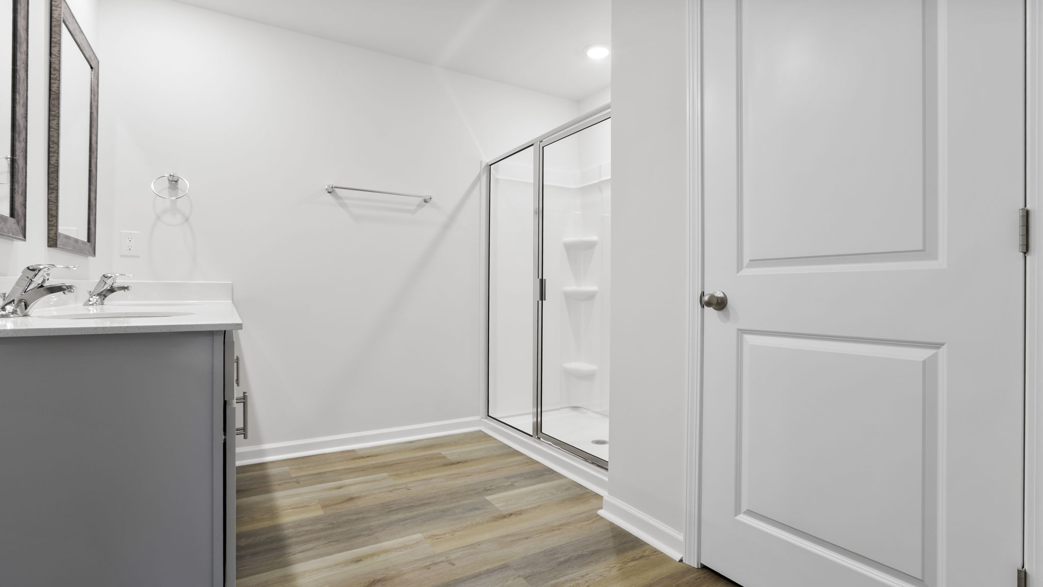 Primary bathroom with dual sink vanity and mirrors.