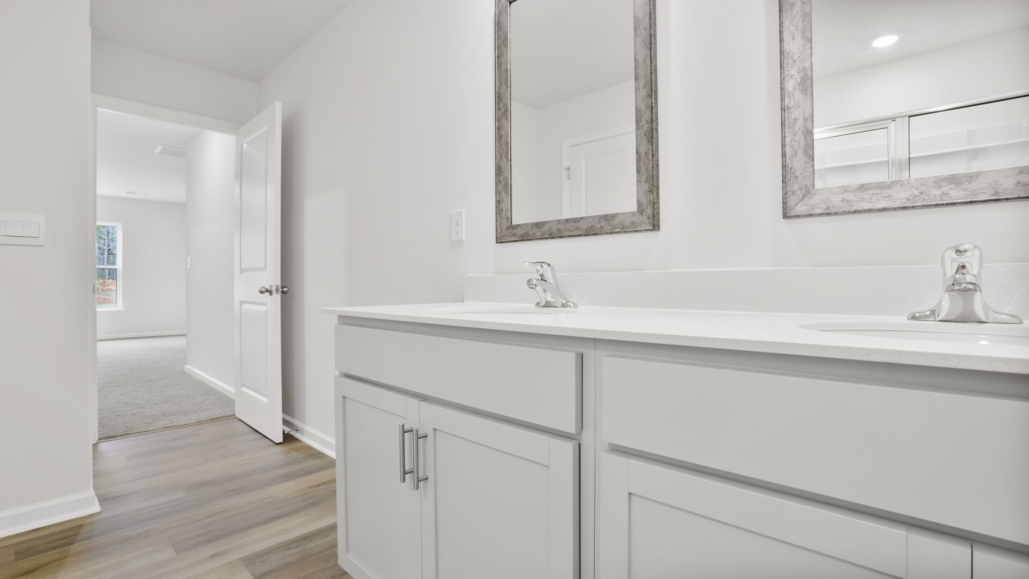Primary bathroom with dual sink vanity and mirrors.