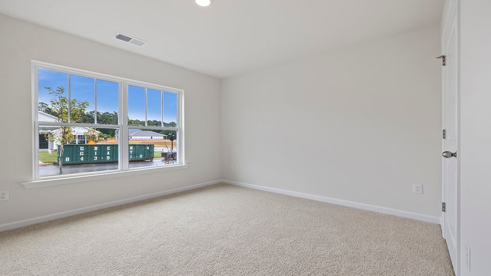 Bedroom with carpet and windows.