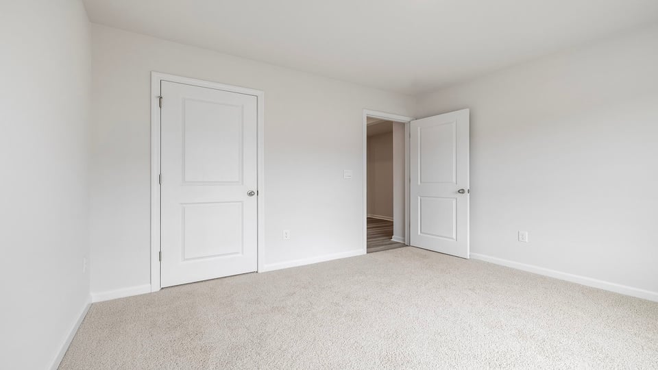 Bedroom with carpet and windows.
