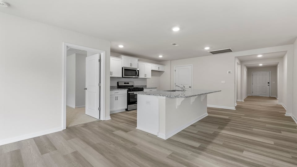 View of open kitchen and hallway to the entrance.