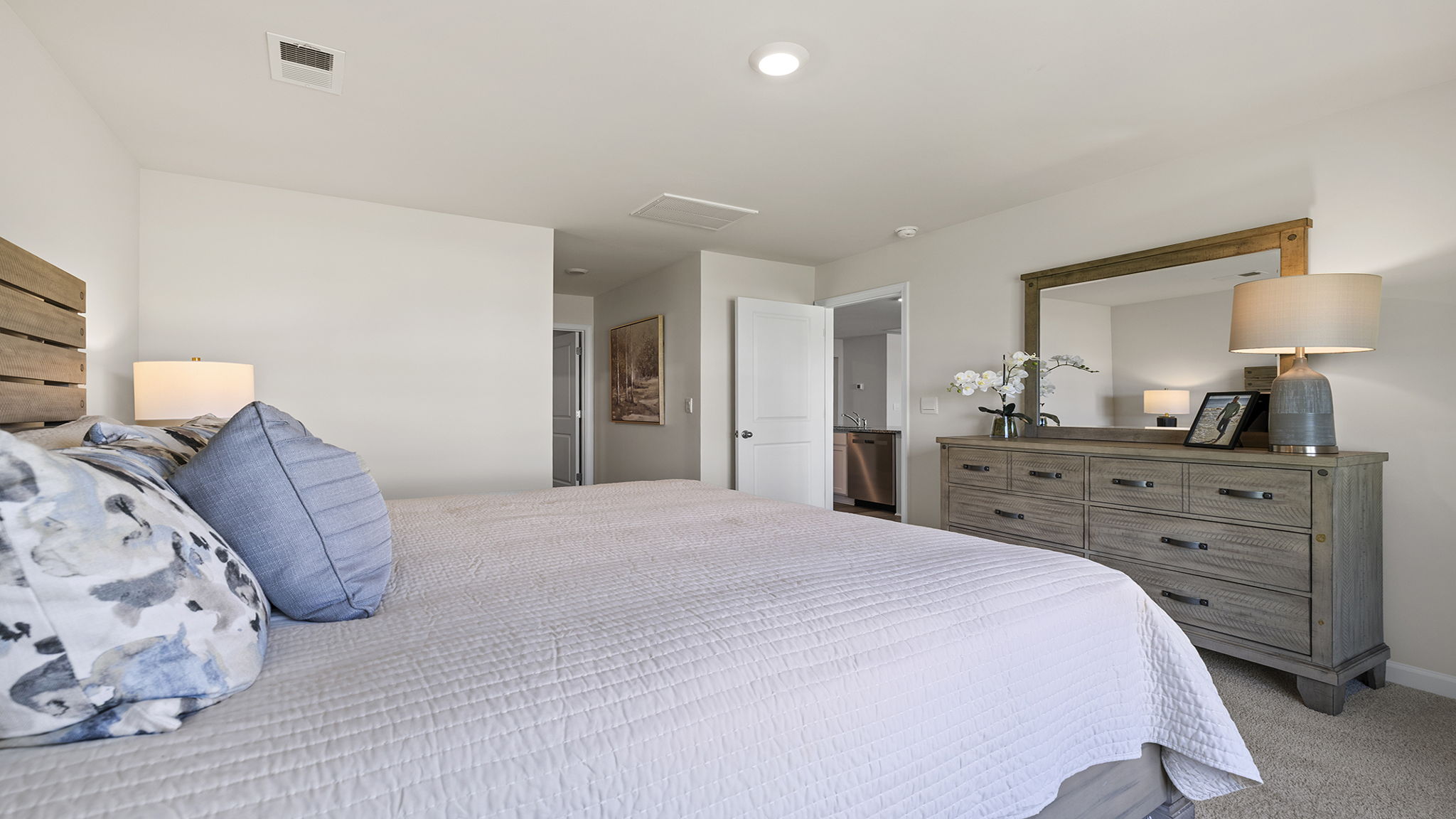 Primary bedroom with carpet and window.