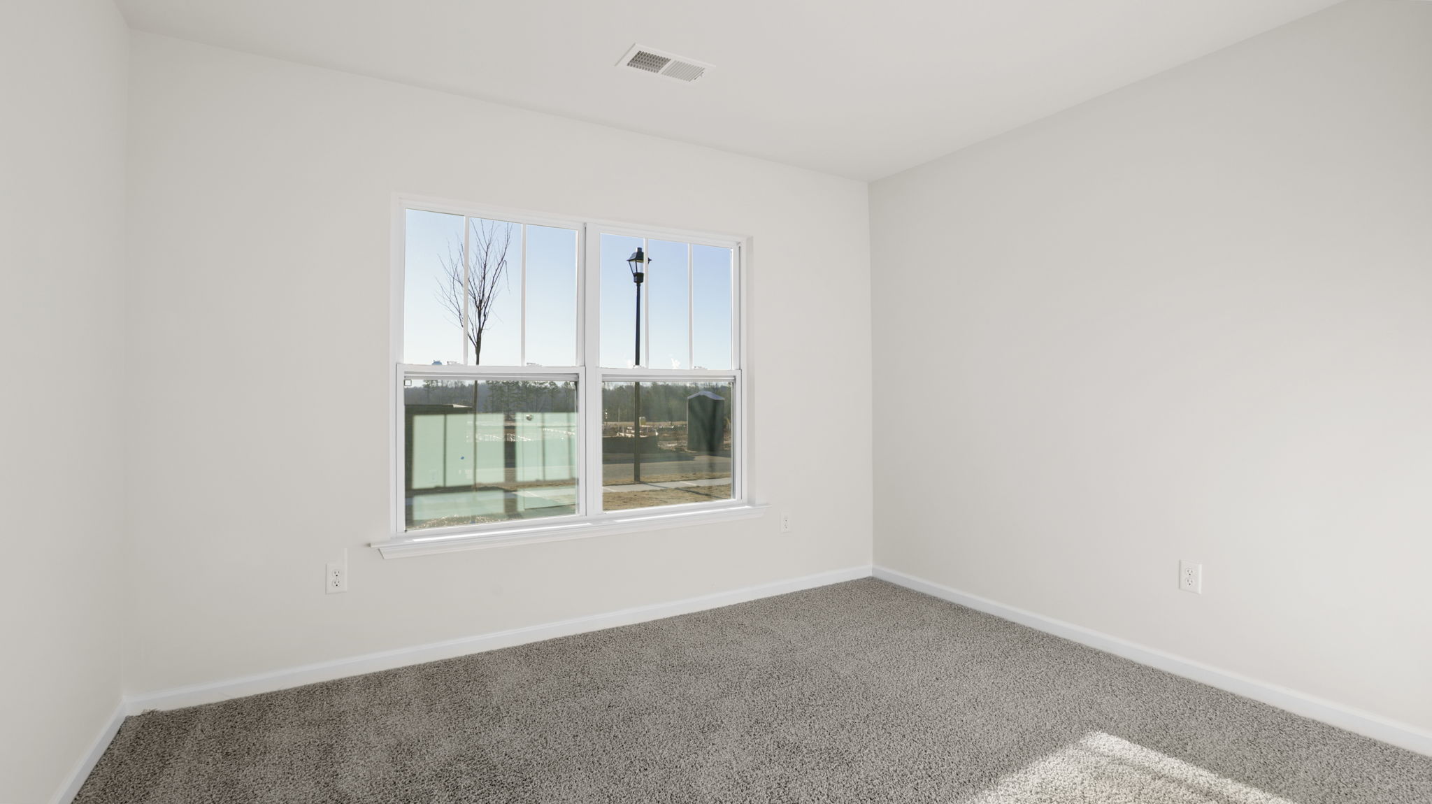 Bedroom with carpet and windows.