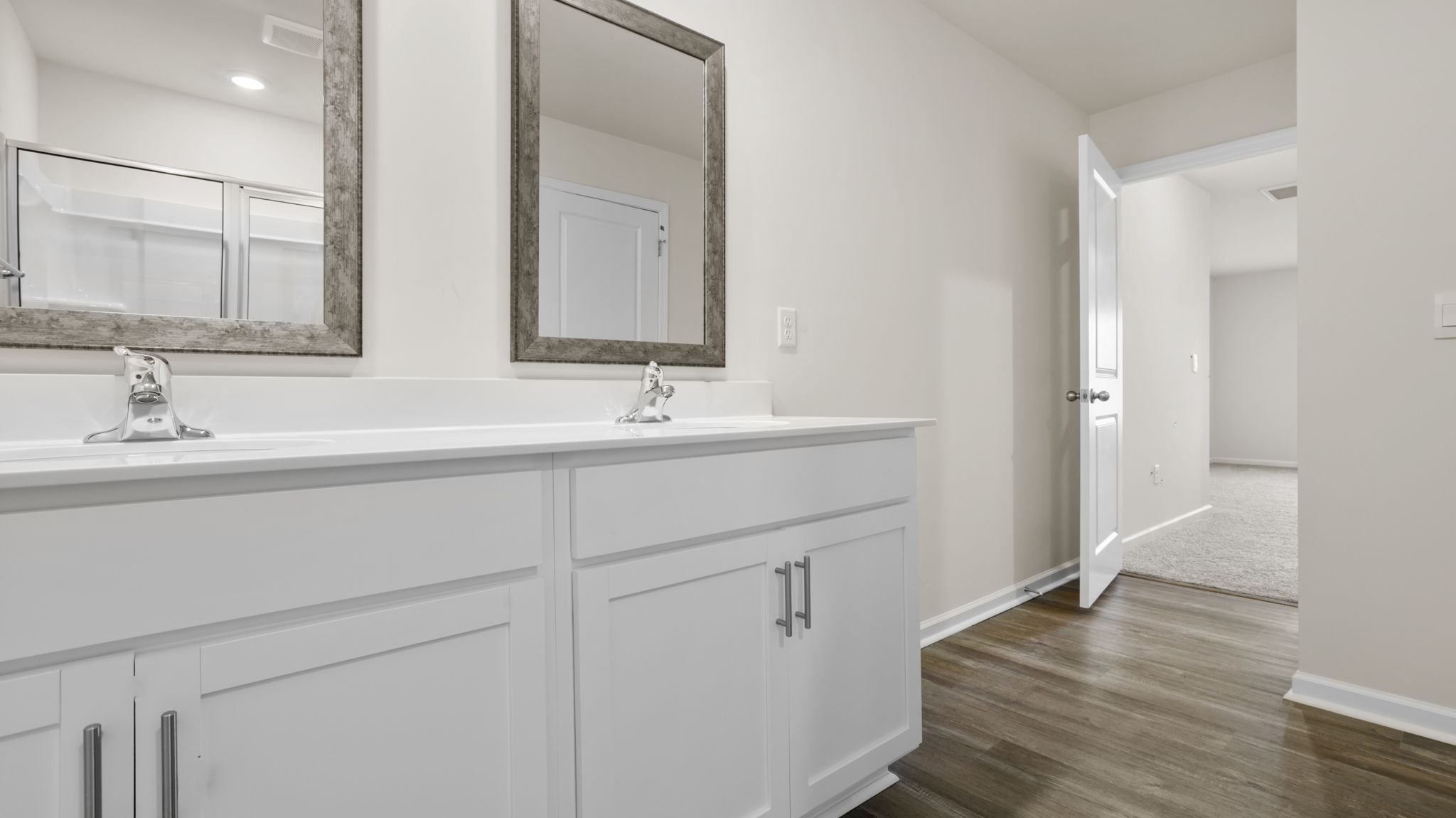 Primary bathroom with dual sink vanity and mirrors.