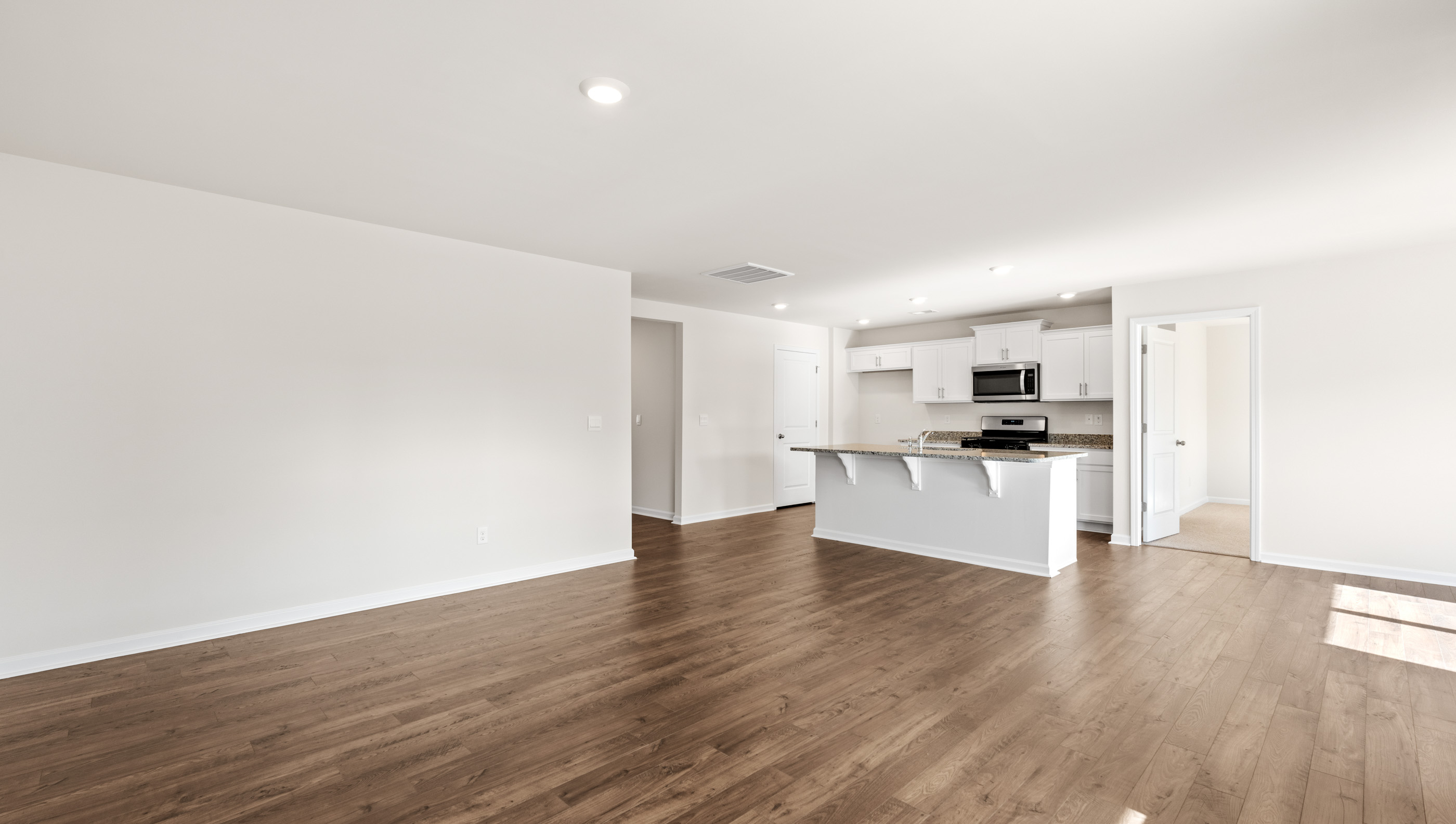 View from family room of kitchen and hallway to the entrance.