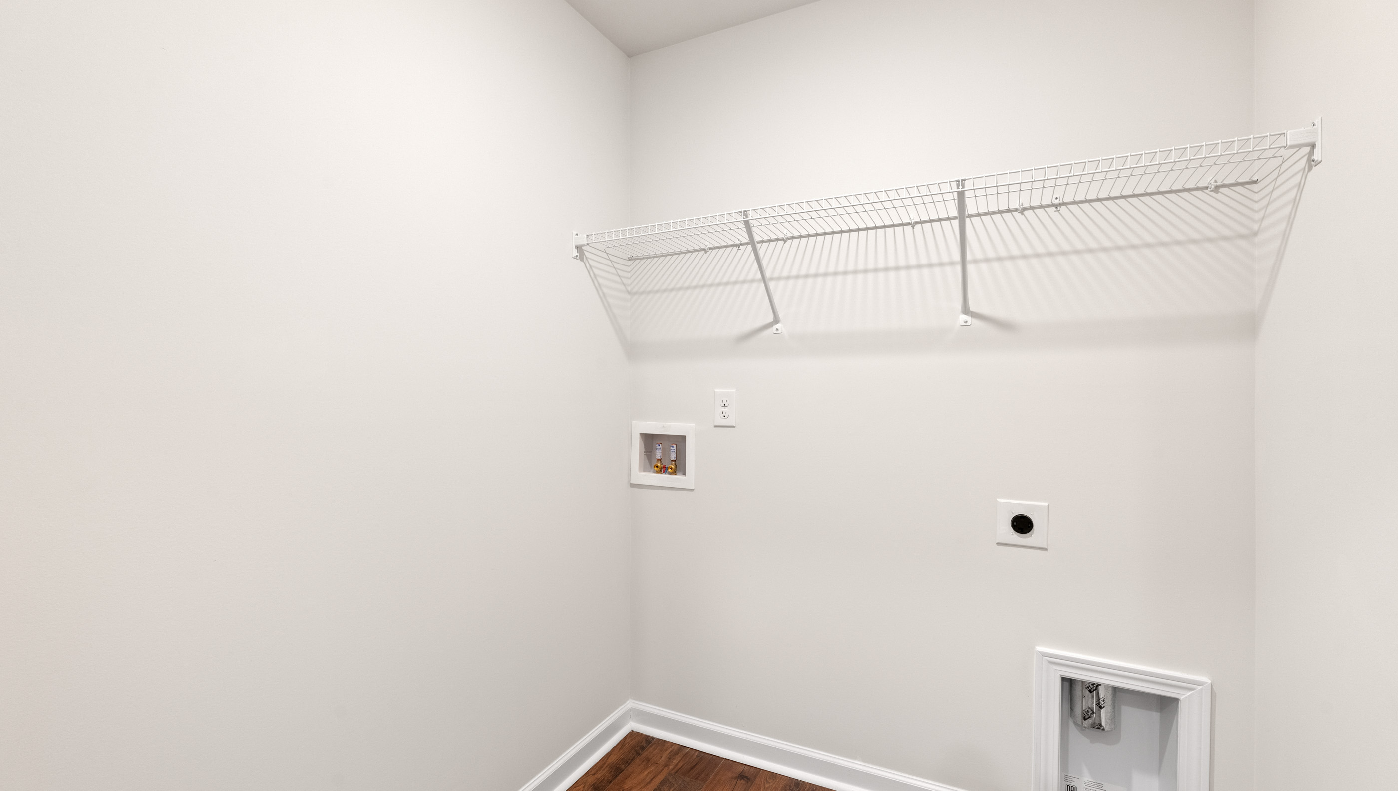 Walk-in laundry room with shelving.