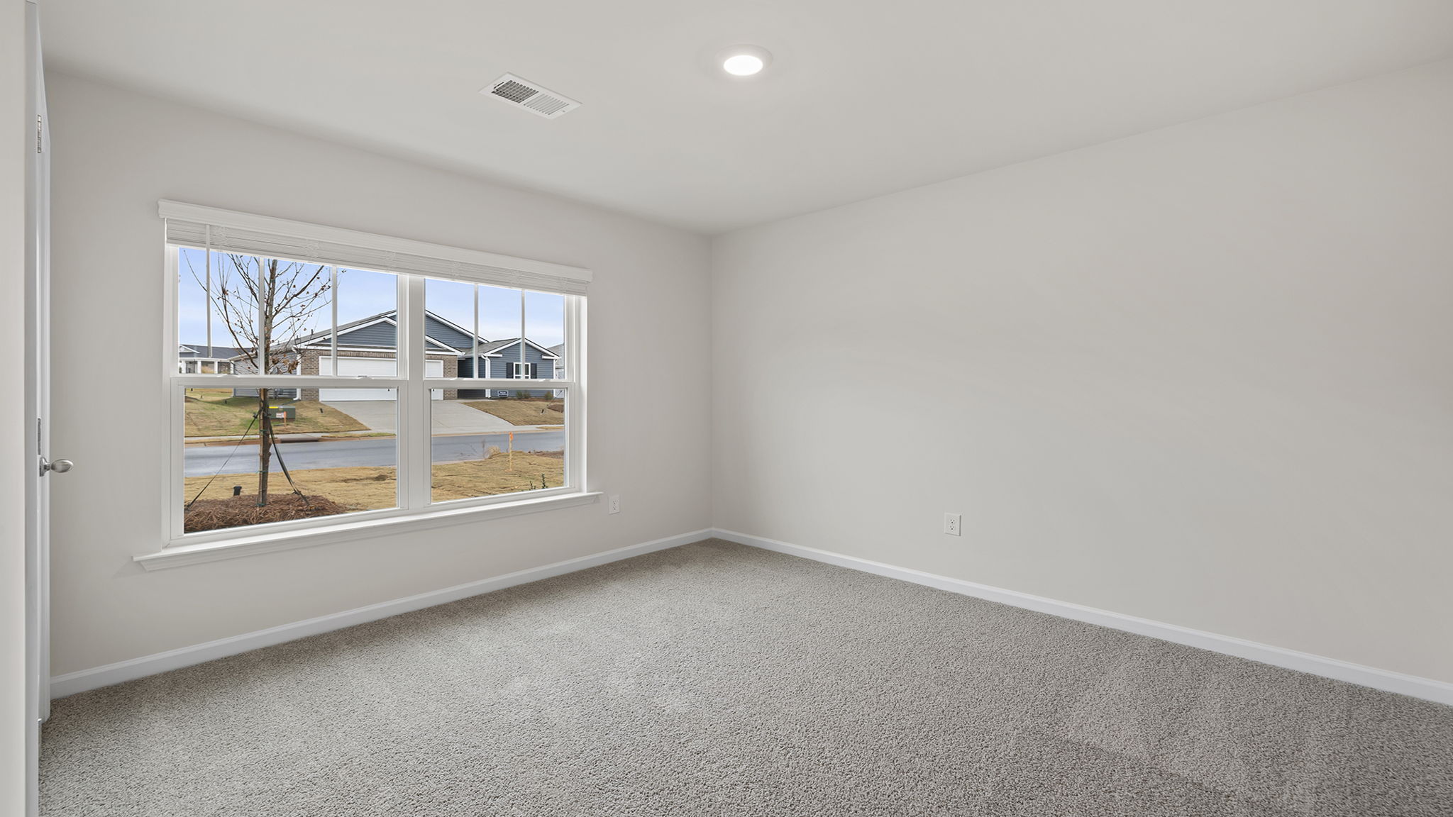 Front bedroom with large window and carpet.