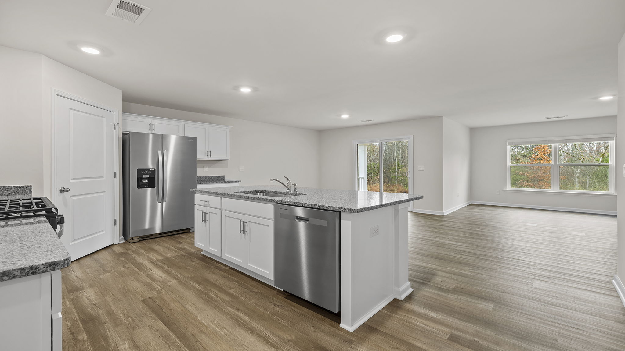 Open floor plan with lots of windows and recessed lighting.