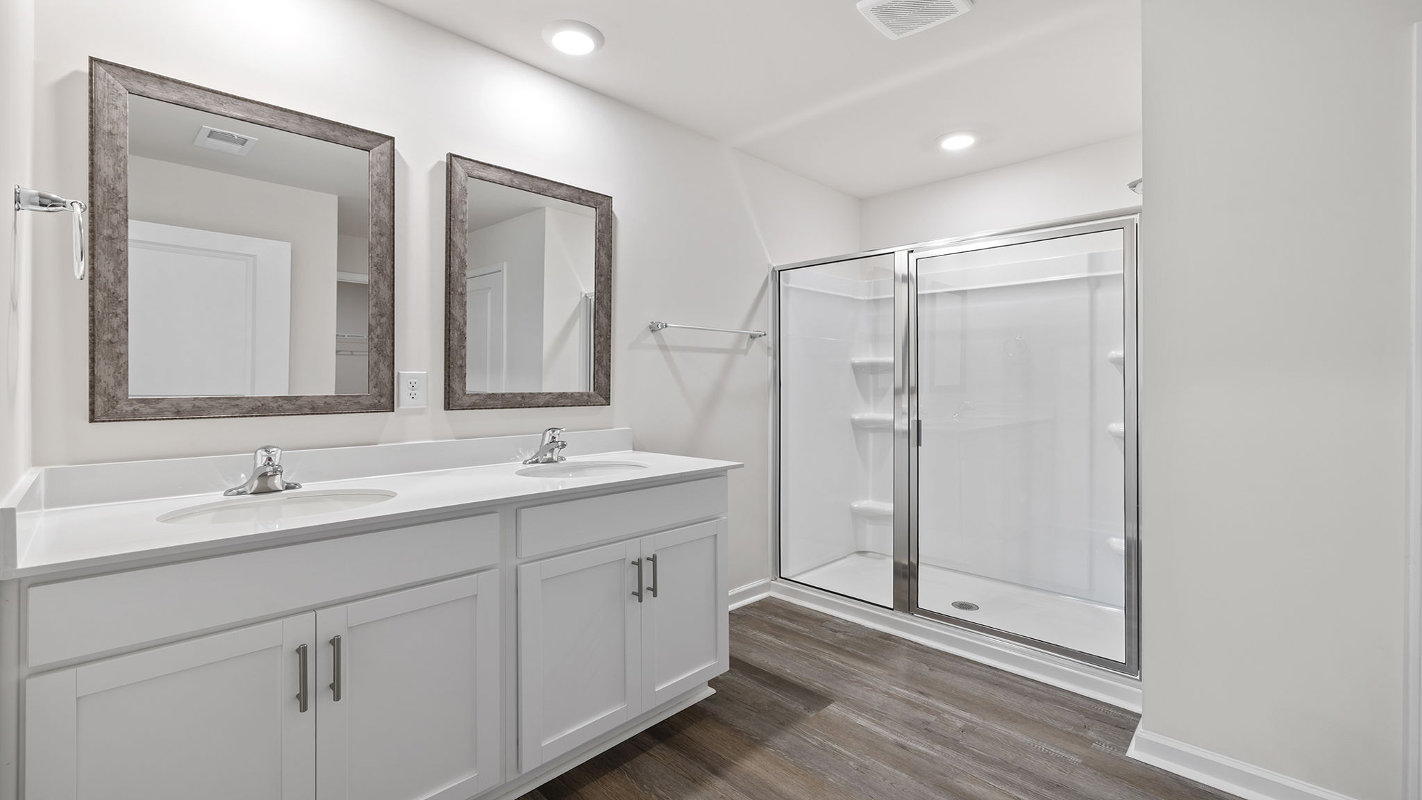Primary bathroom with dual sink vanity and walk-in shower.