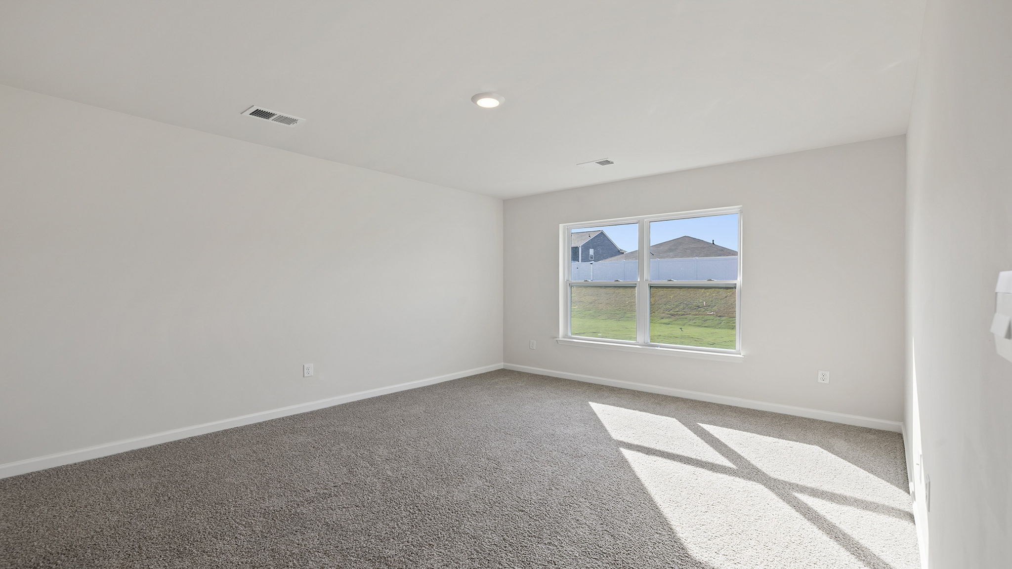 Primary bedroom with window and carpet.