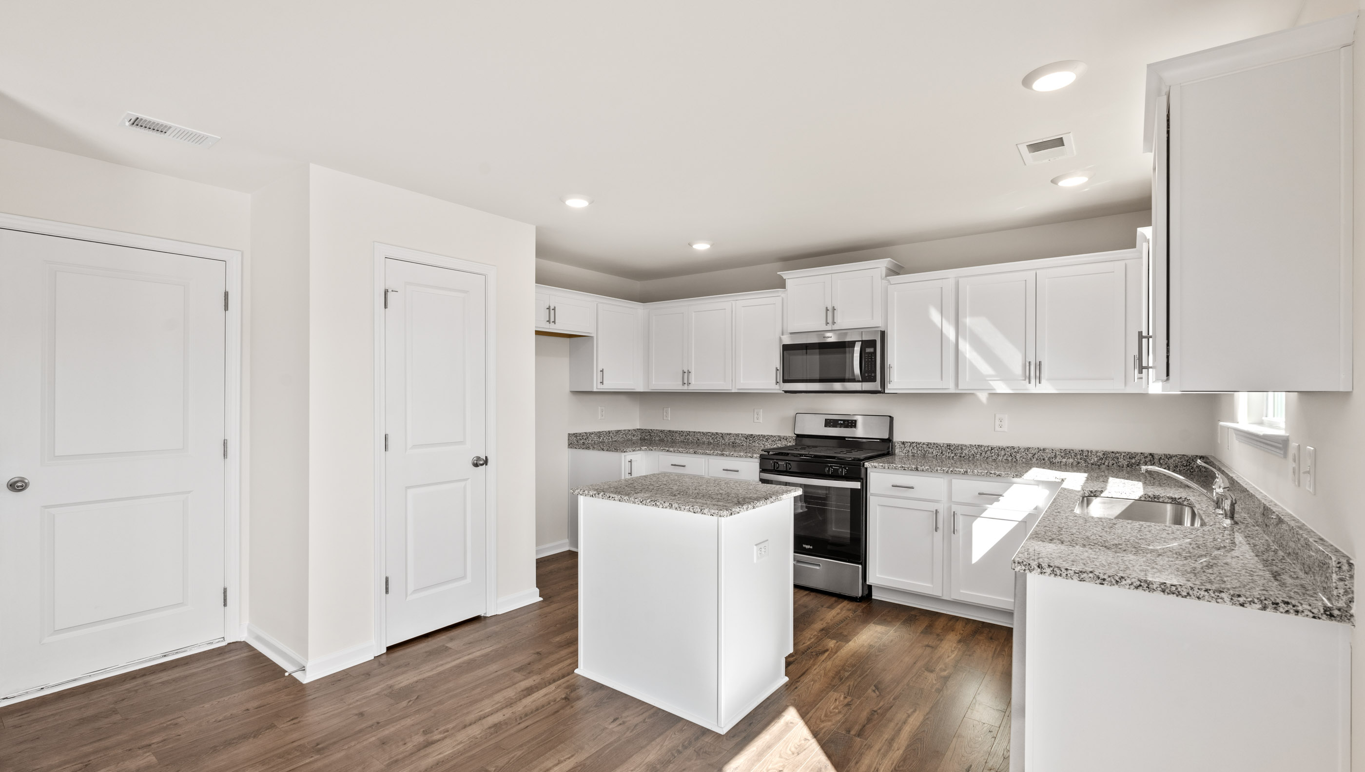 Kitchen and island with granite counter tops.