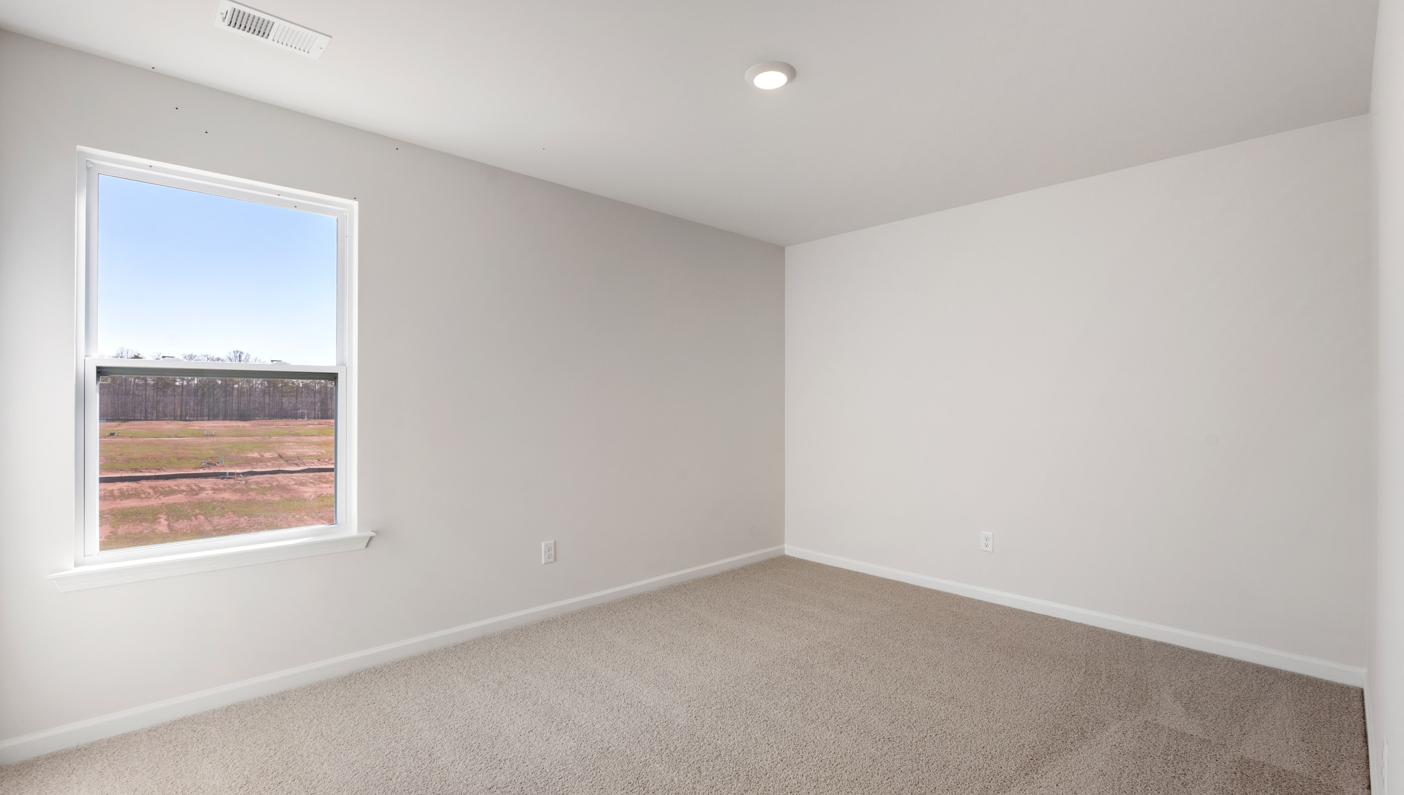 Bedroom with carpet and windows.