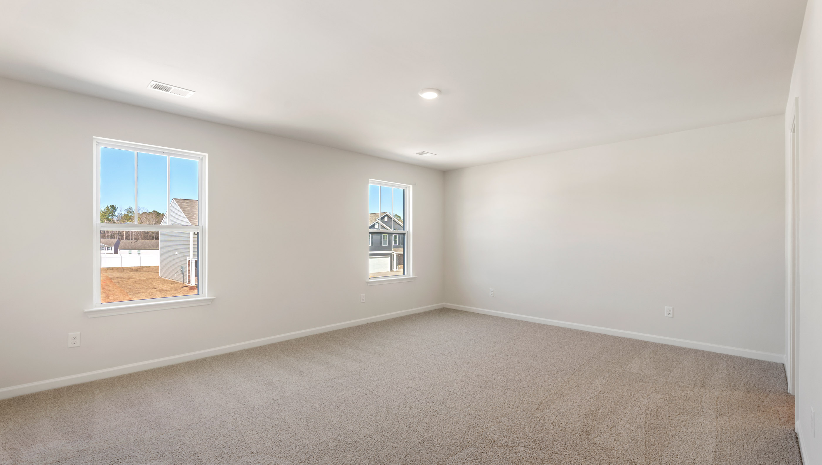 Bedroom with carpet and windows.