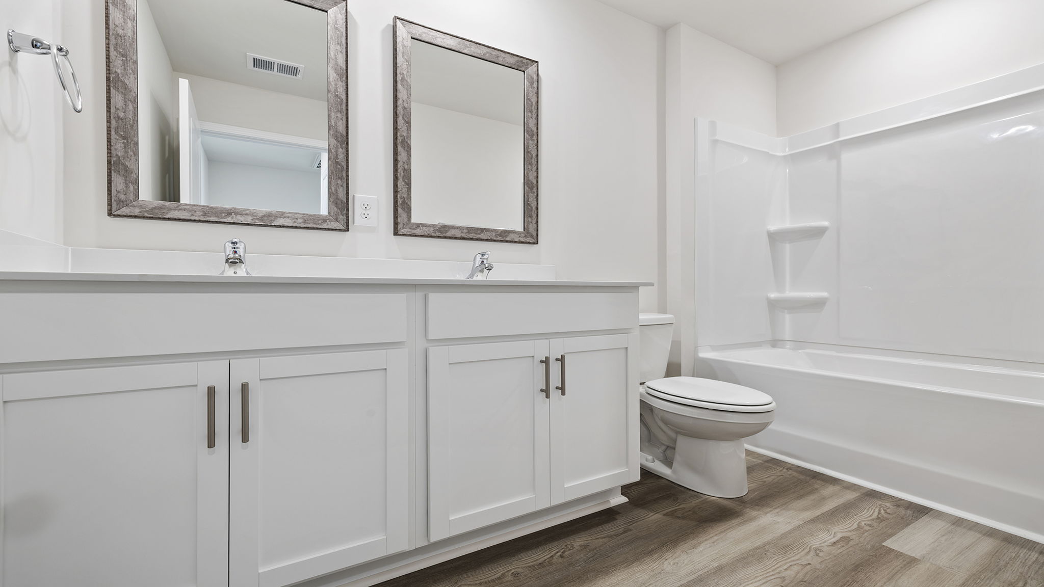 View of hall bath with dual sinks and combination tub and shower.