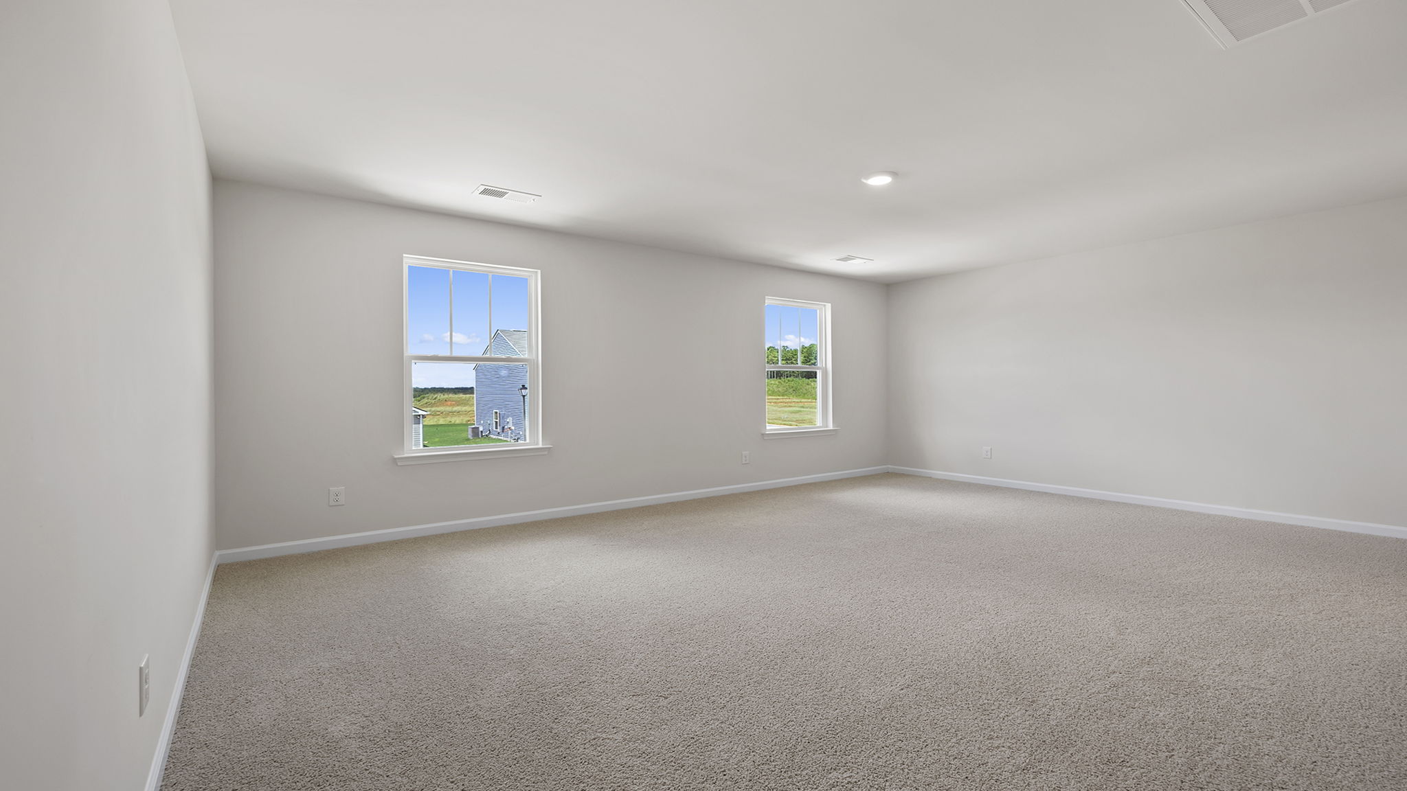 Primary bedroom and two large windows allowing natural light.