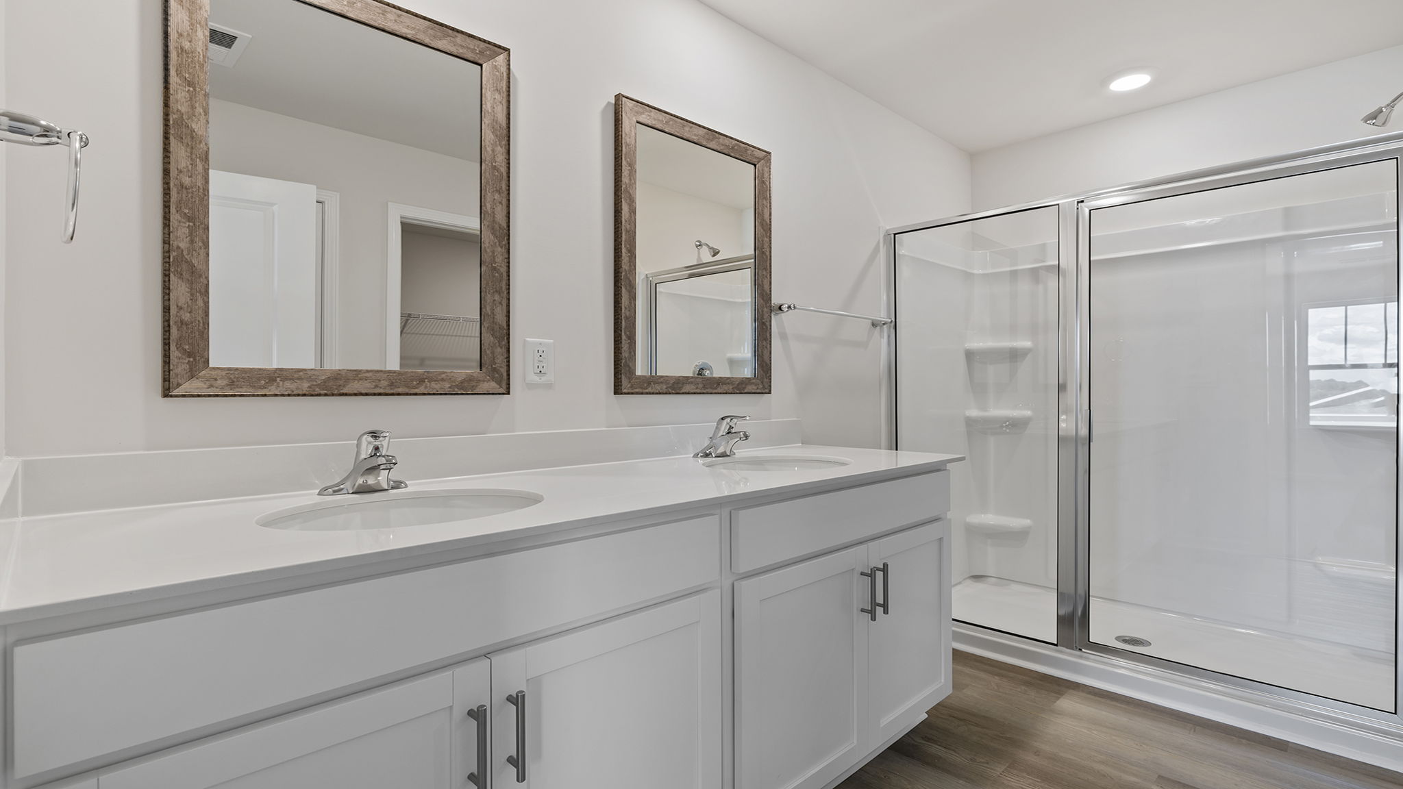 Primary bath with walk in shower and dual sink vanity.