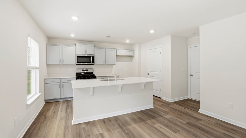Kitchen and island with quartz countertops.