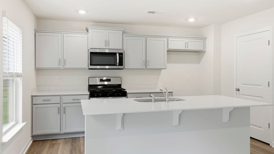 Kitchen and island with quartz countertops.