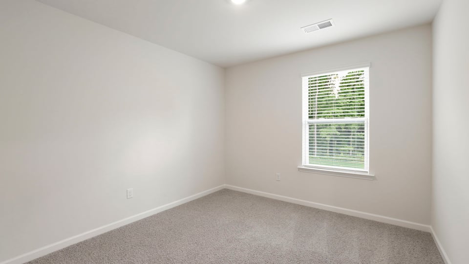 Bedroom with carpet and window.
