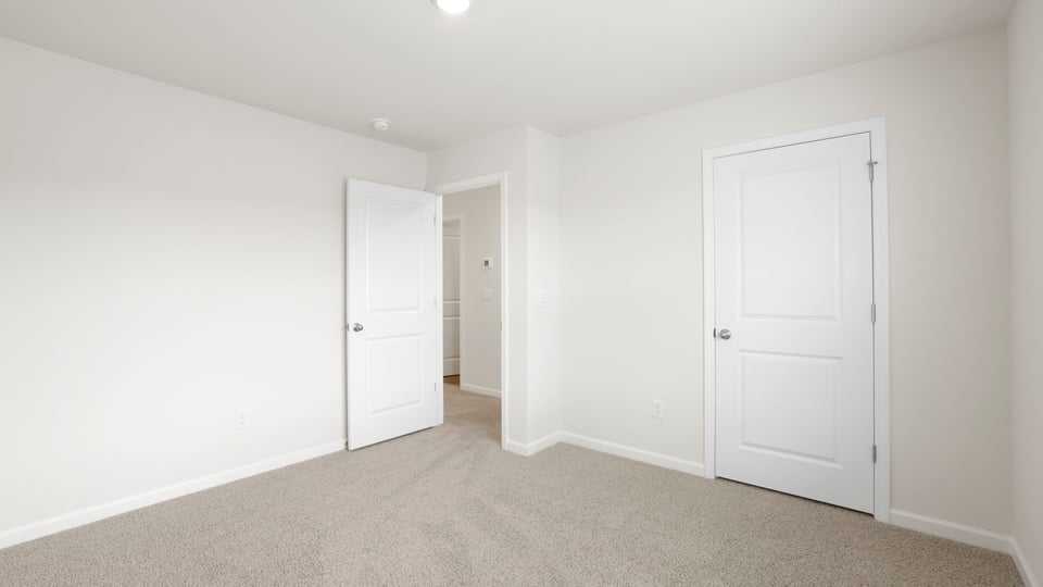 Bedroom with carpet and window.