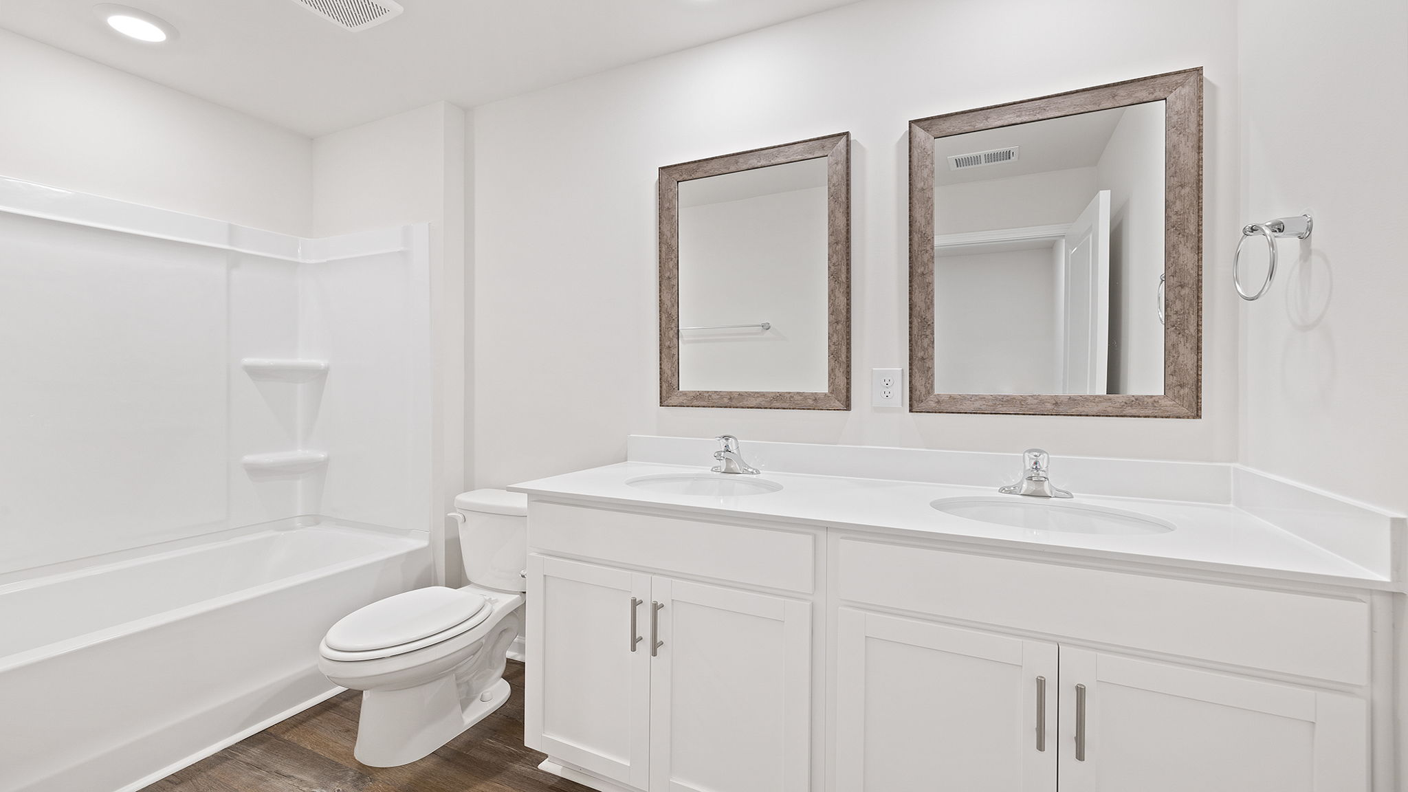 Hall bathroom with dual sink vanity and combination shower / tub.