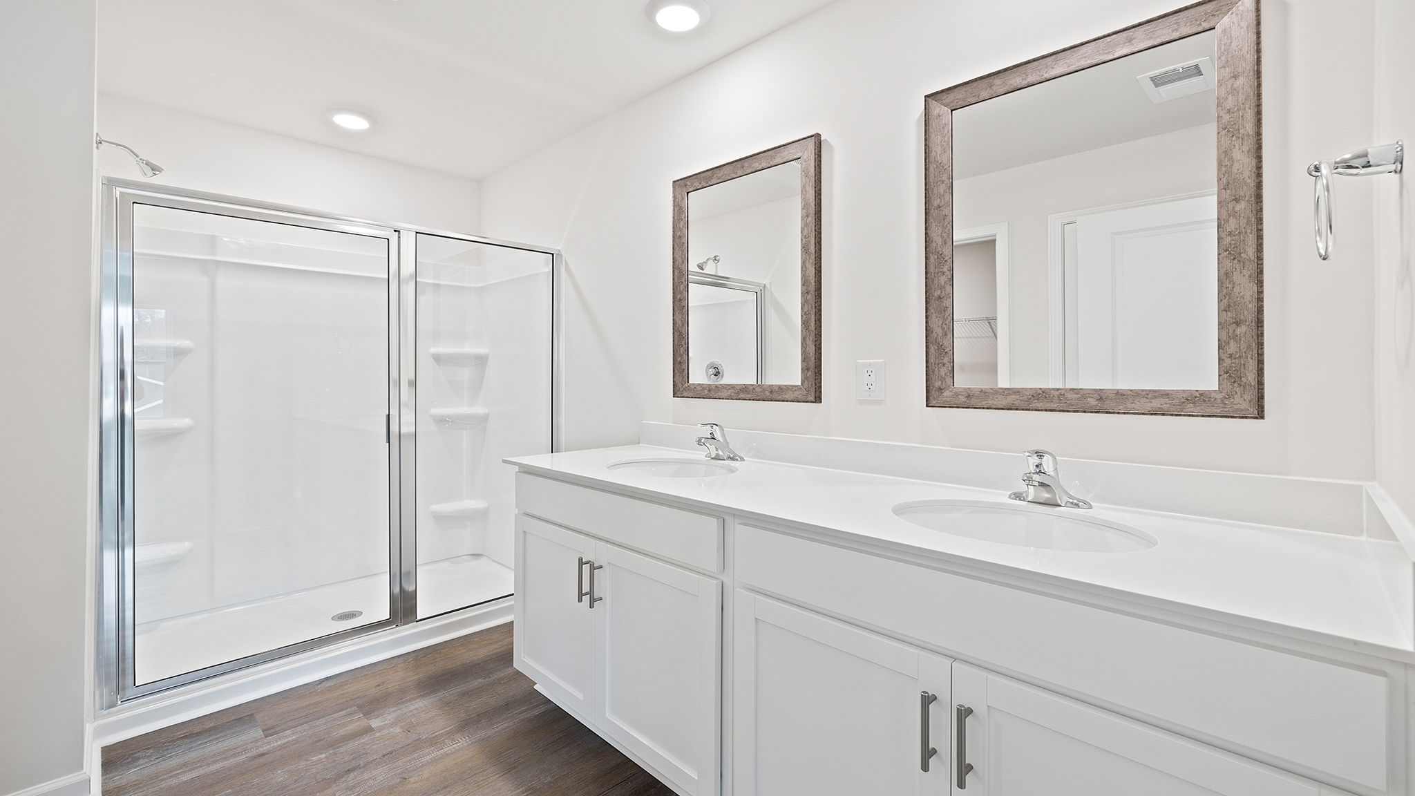 Primary bathroom with dual sink vanity and walk-in shower.