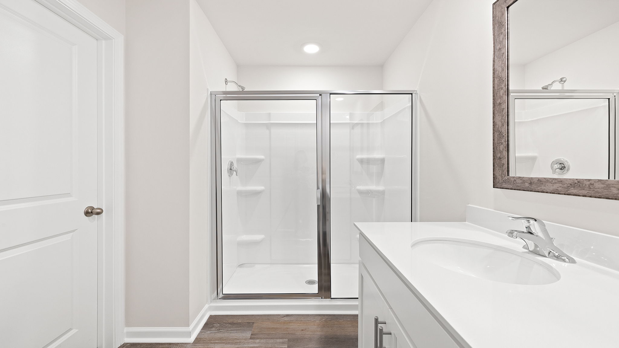 Primary bathroom with dual sink vanity and walk-in shower.
