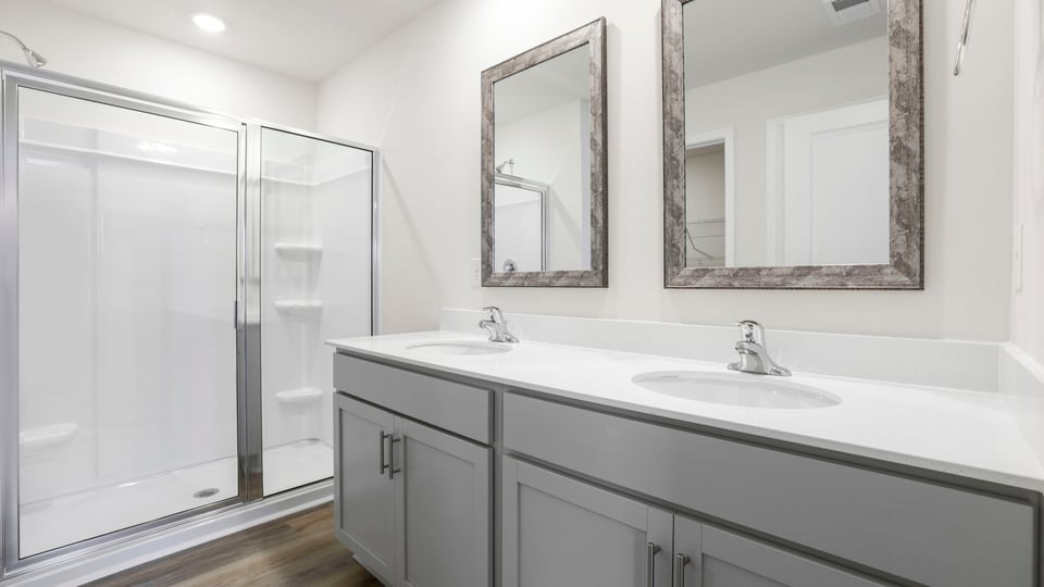 Bathroom with double vanity sink and walk in shower.